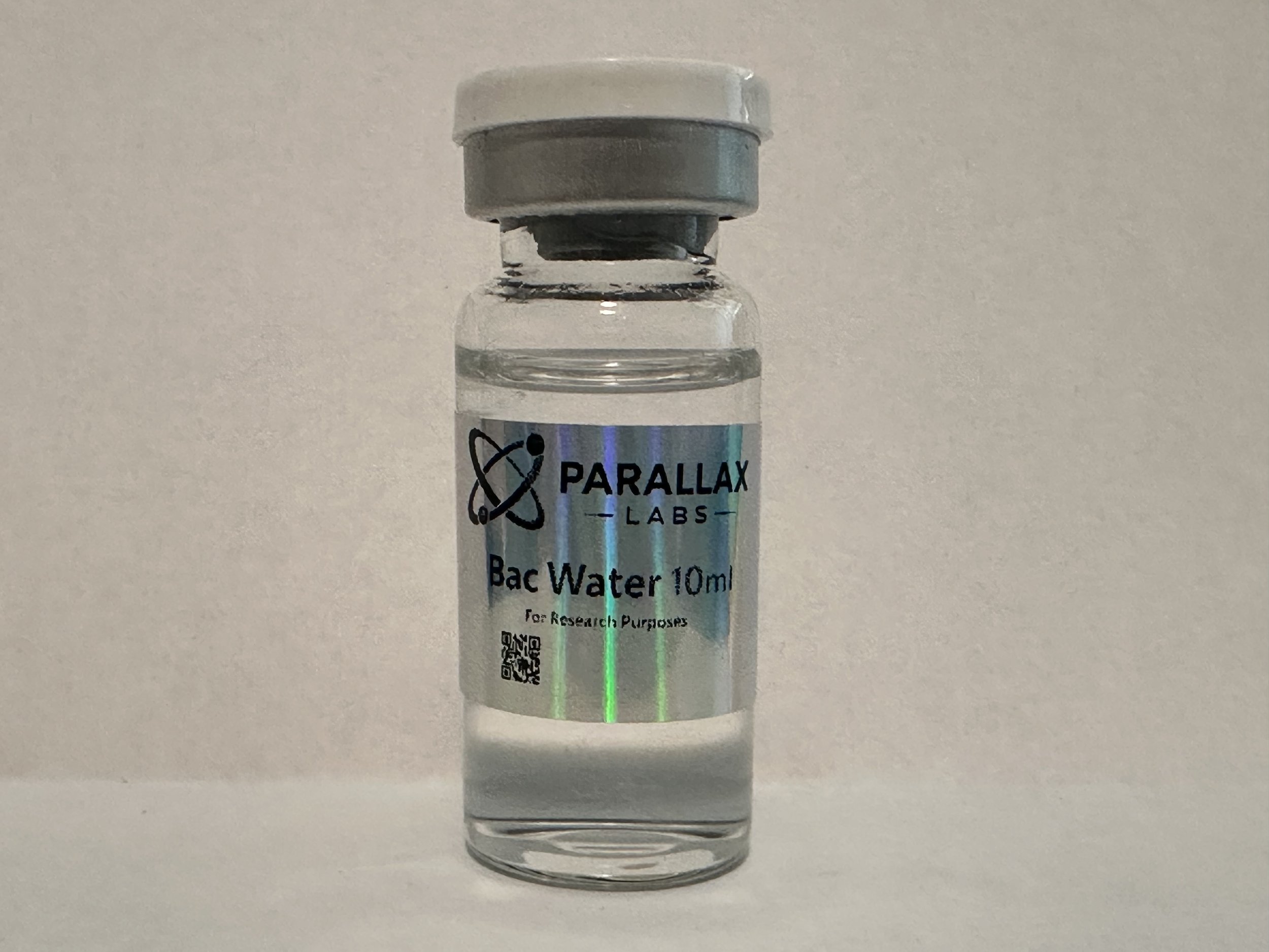 Small glass vial labeled 'PARALLAX LABS Bac Water 10ml for research purposes' with a QR code, sealed with a gray cap, against a plain background.