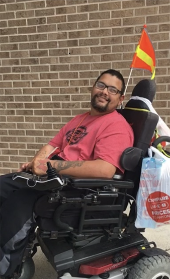 man smiling in a wheelchair with safety flag