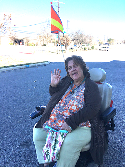 Woman smiling and waving in wheelchair