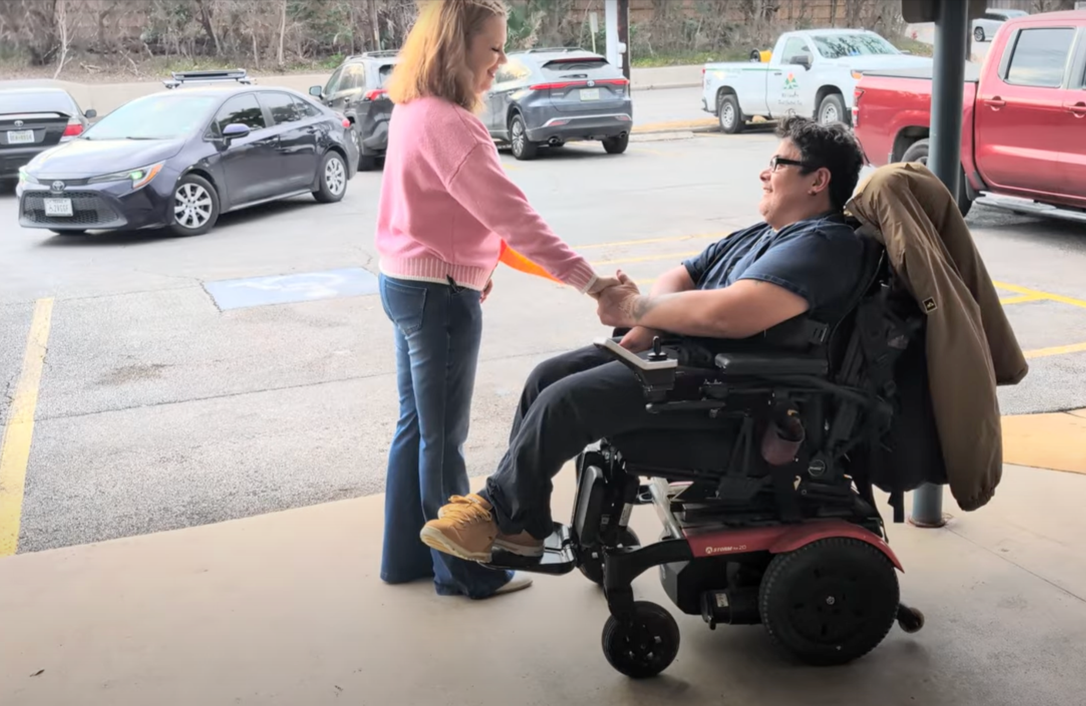 Female volunteer greeting wheelchair user with safety  flag