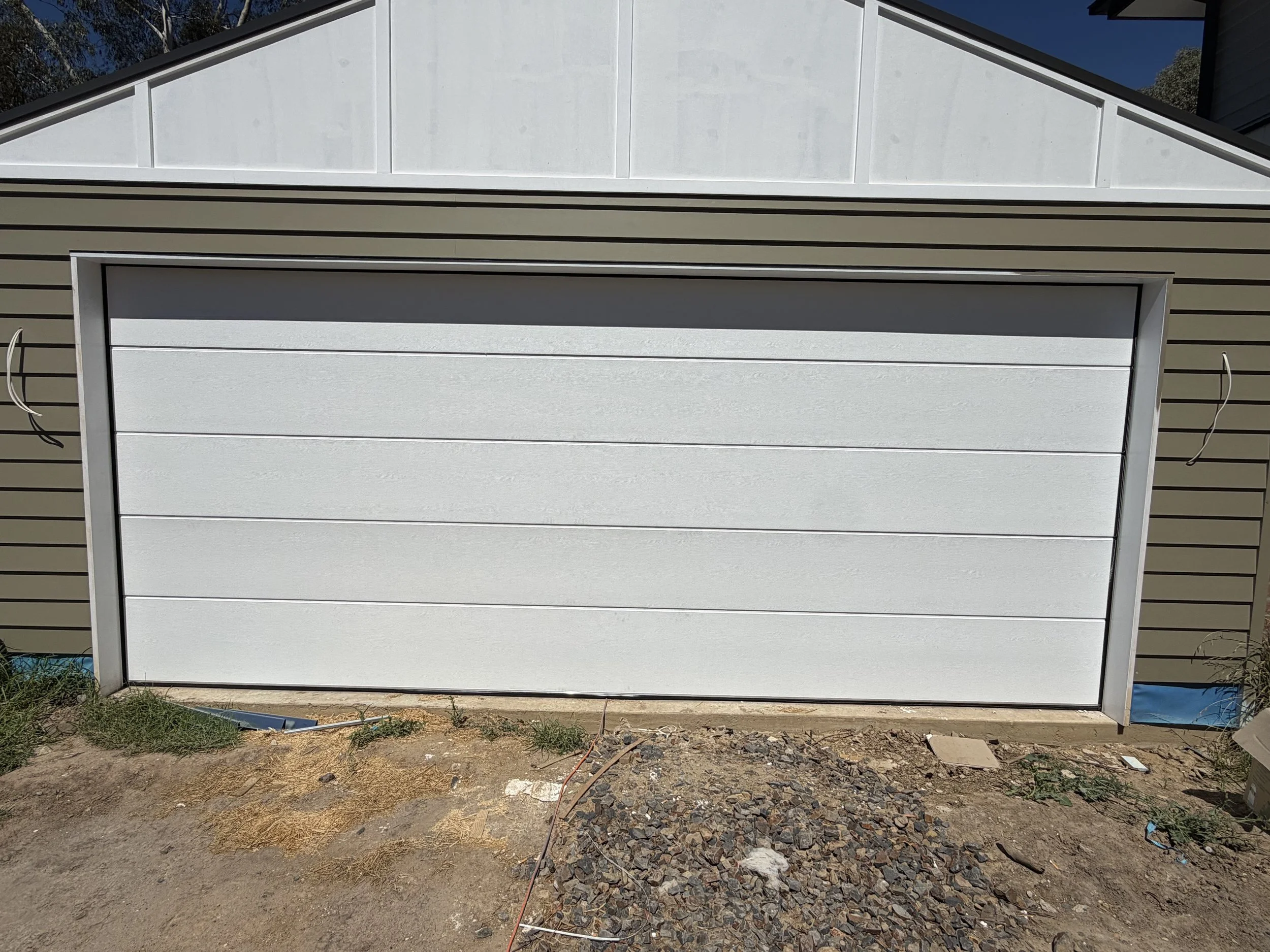 A white garage door serviced for improved performance and safety