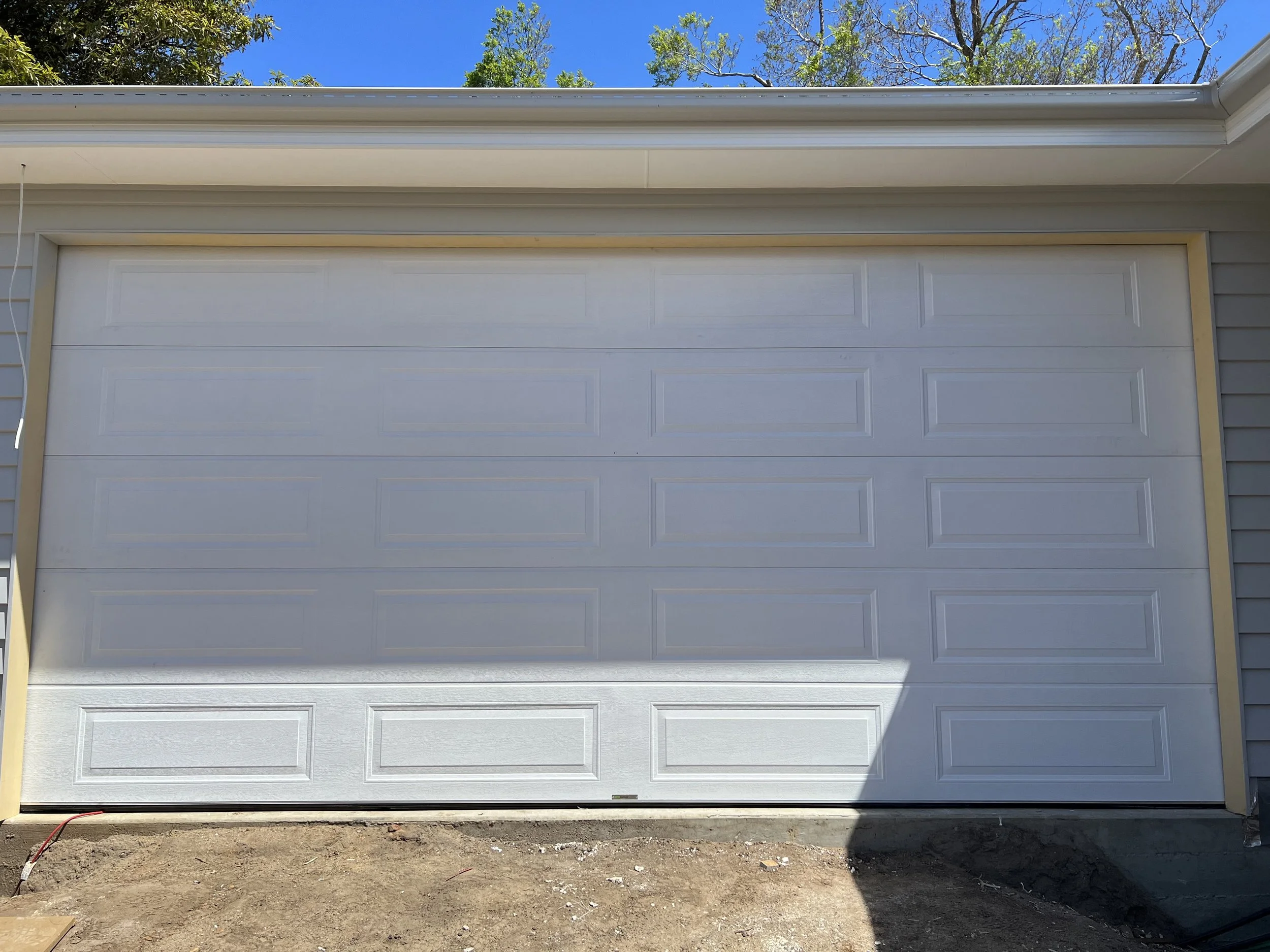 white garage door serviced for improved performance and safety