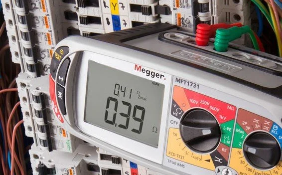 Digital multimeter measuring resistance inside an electrical panel with circuit breakers.