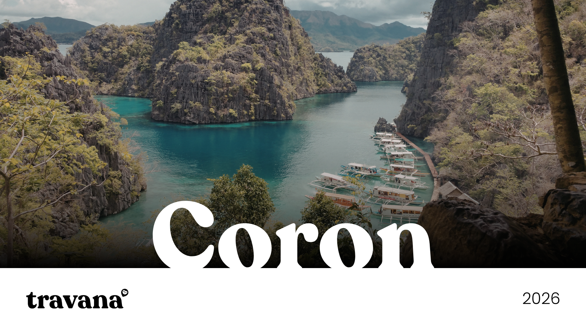 A scenic view of a bay surrounded by tall, rocky, forested cliffs with turquoise water and a row of boats docked along a narrow pier. The image is labeled "Coro" and includes the brand name "travana" and the year "2026".