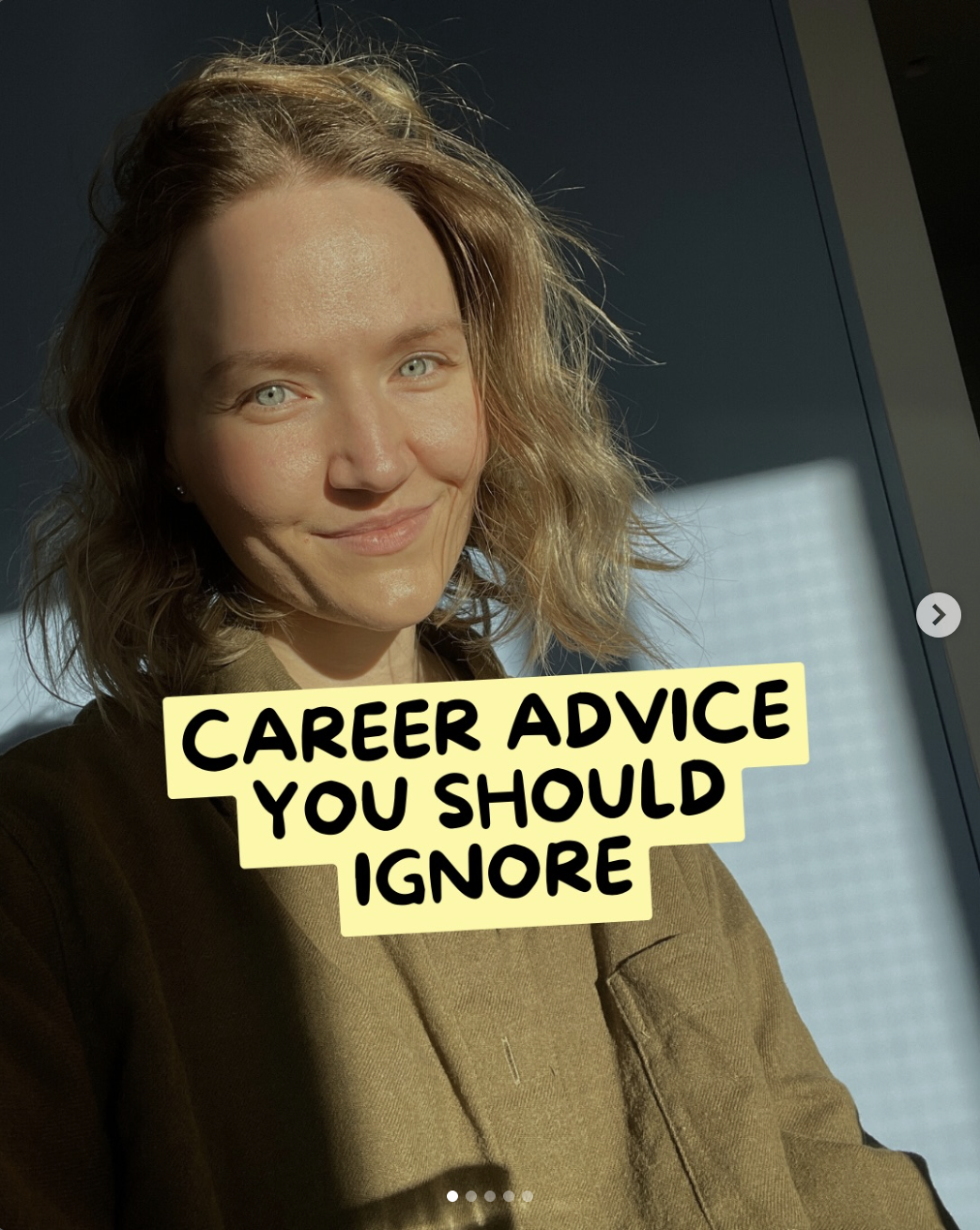 A woman with shoulder-length curly blonde hair and blue eyes smiling at the camera. She wears a brown blazer, standing in front of a window with sunlight casting shadows. Text overlay says 'Career Advice You Should Ignore'.