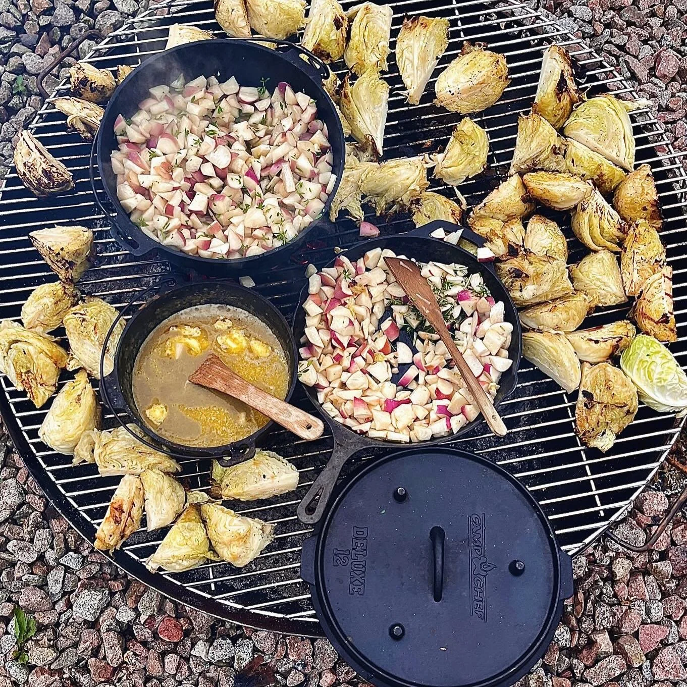 Geroosterde artisjoffenschubben, mengsels van chopped bleekselderij en radijs, en gesmolten boter op een barbecu grill.