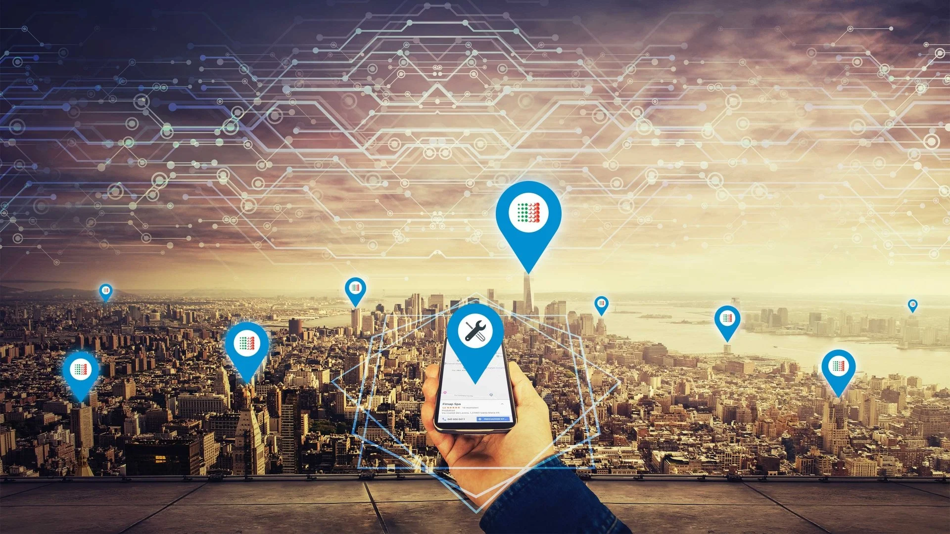 A person holding a smartphone with a repair icon over a cityscape at sunset. Blue location pins with a grid pattern are superimposed over various parts of the city, connected by digital lines and circuits, representing smart city or IoT technology.
