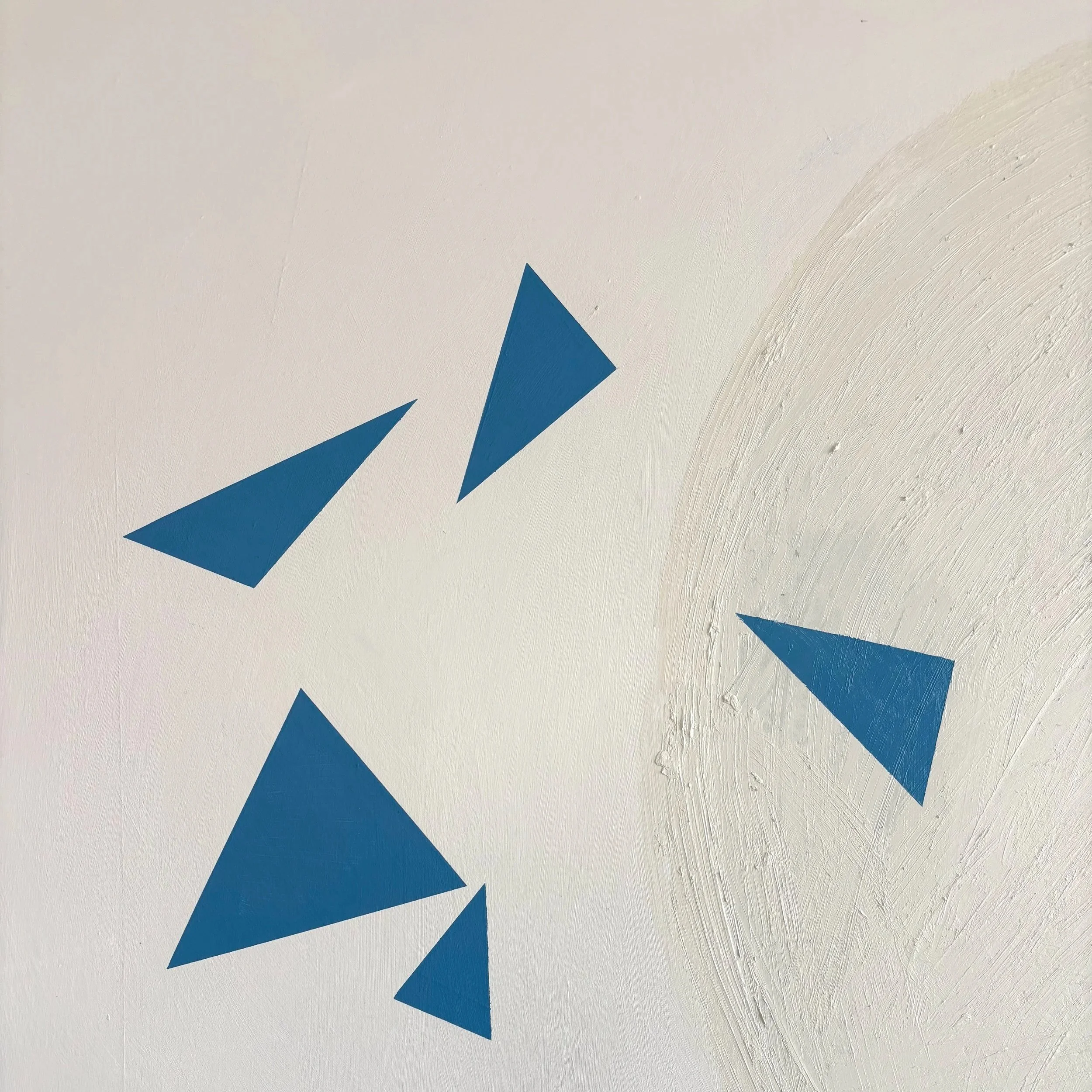 Close-up of a white wall with a blue geometric design, showing textured paint strokes.