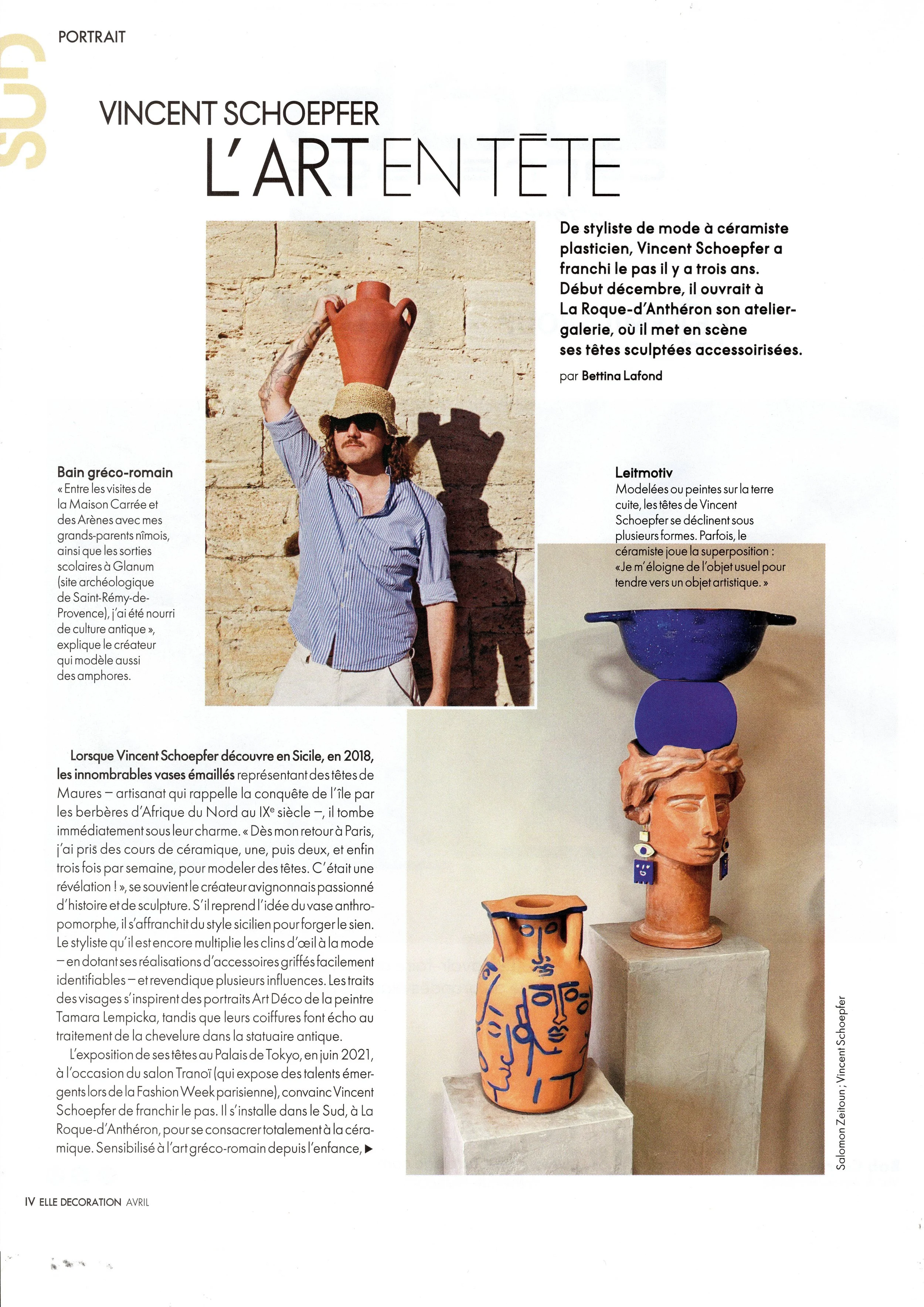 A woman wearing a sun hat and sunglasses, holding a large terracotta vase with a handle. There are also two other decorated terracotta vases, one with blue patterns and another with blue lettering.