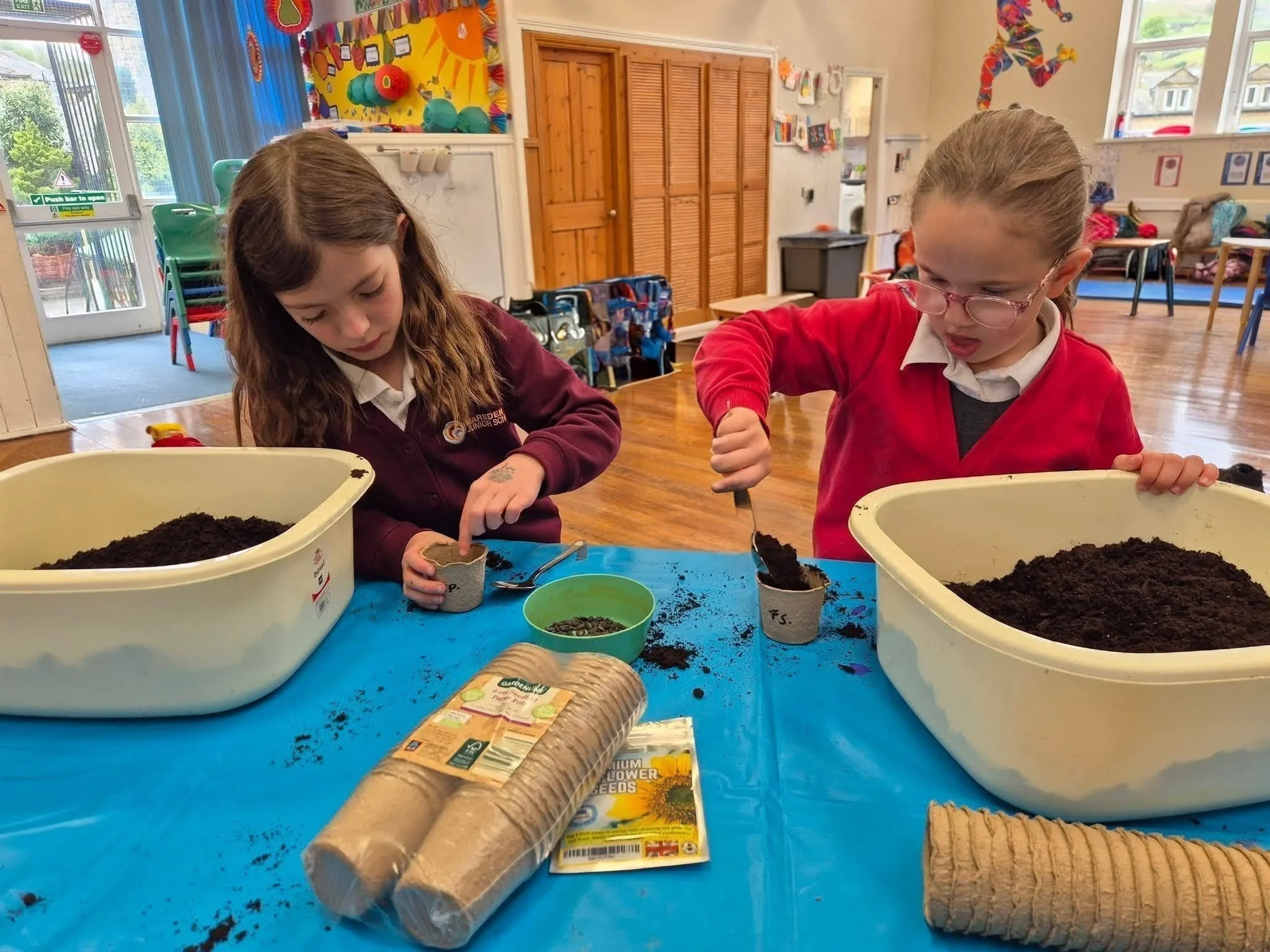 Children doing a gardening activity at Marsden Kids' Club in Marsden, West Yorkshire.