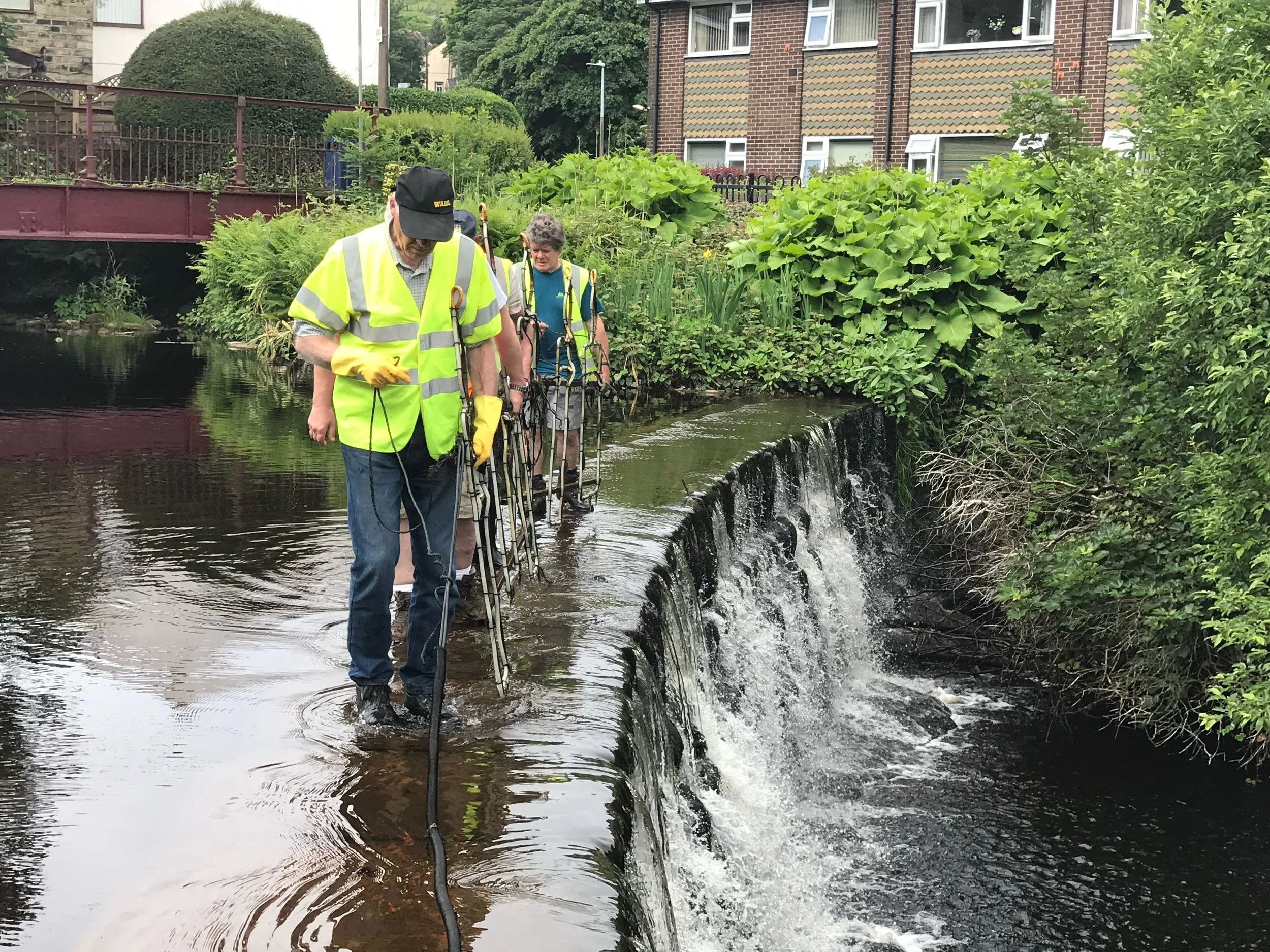 Volunteers helping put up Christmas lights in the weir in Marsden, West Yorkshire.