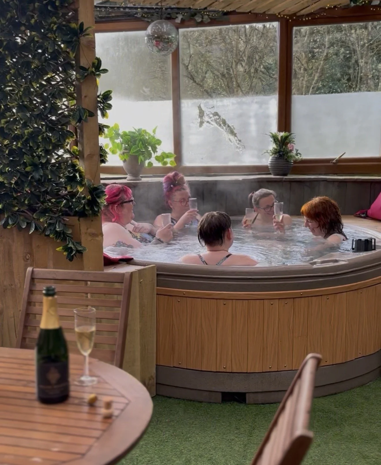 Ladies enjoying a glass of fizz in a hot tub at Wild in Marsden, West Yorkshire.