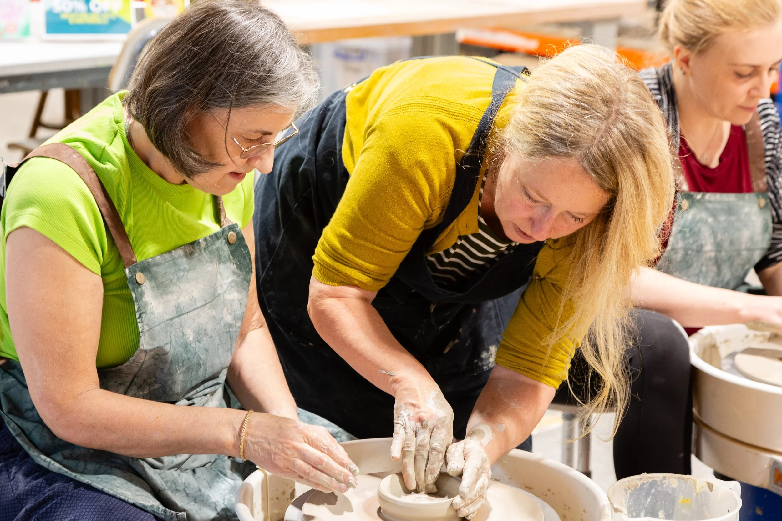 An instructor helping a student at a pottery class at Globe Arts, West Yorkshire.