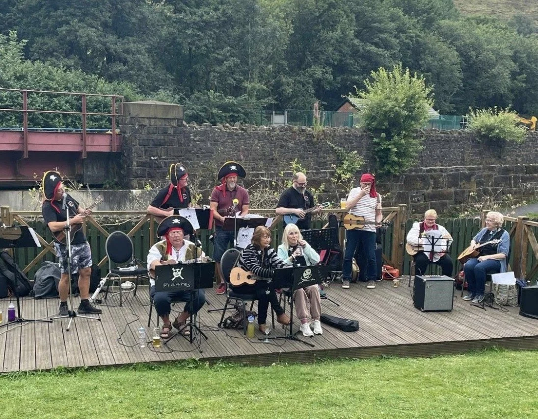 The MUCIPUPS ukulele group of Marsden, West Yorkshire, playing their instruments.