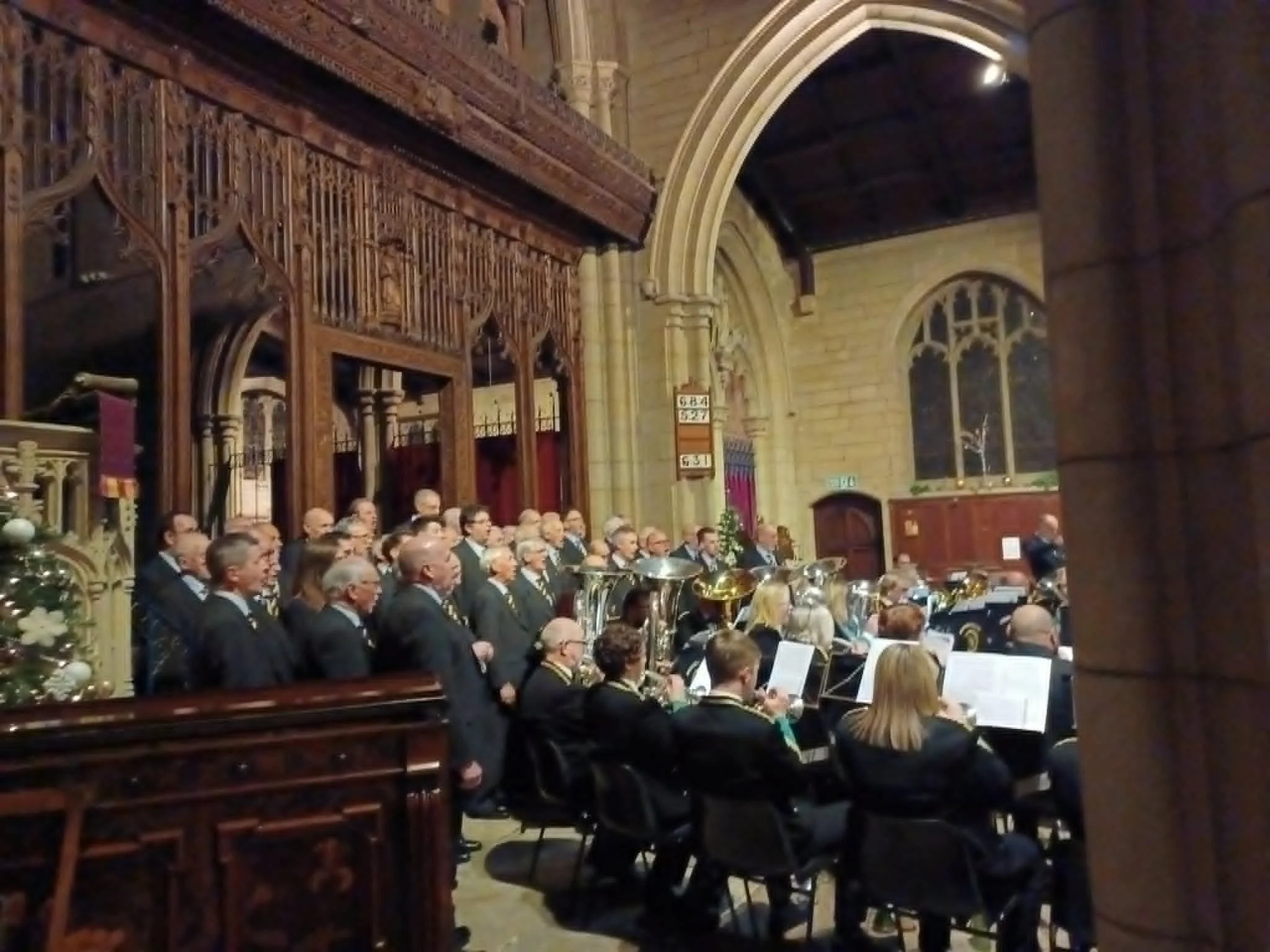 A brass band and choir at Christmas in St. Bartholomew's Church, Marsden, West Yorkshire.