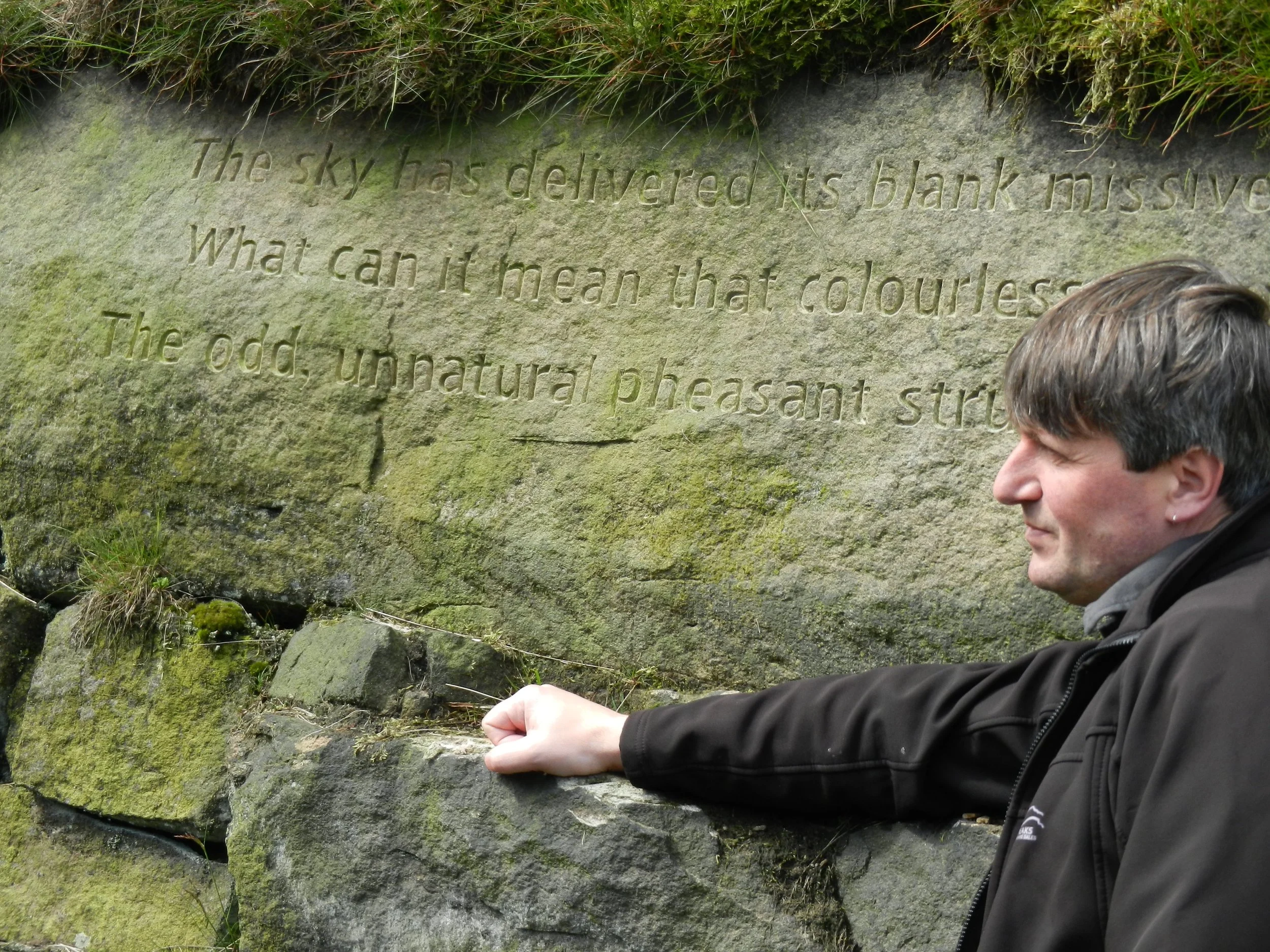 Poet Laureate Simon Armitage standing next to the 'Snow' Stanza Stone.