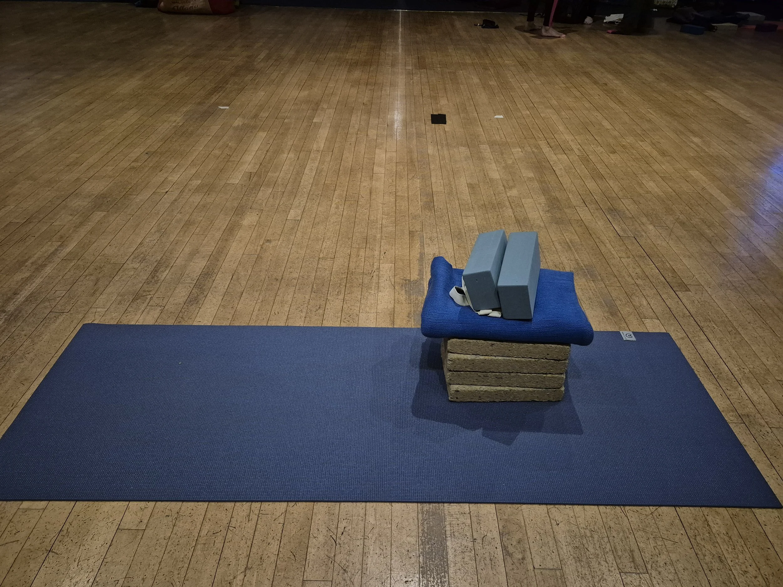 A yoga mat and various items ready for a class.