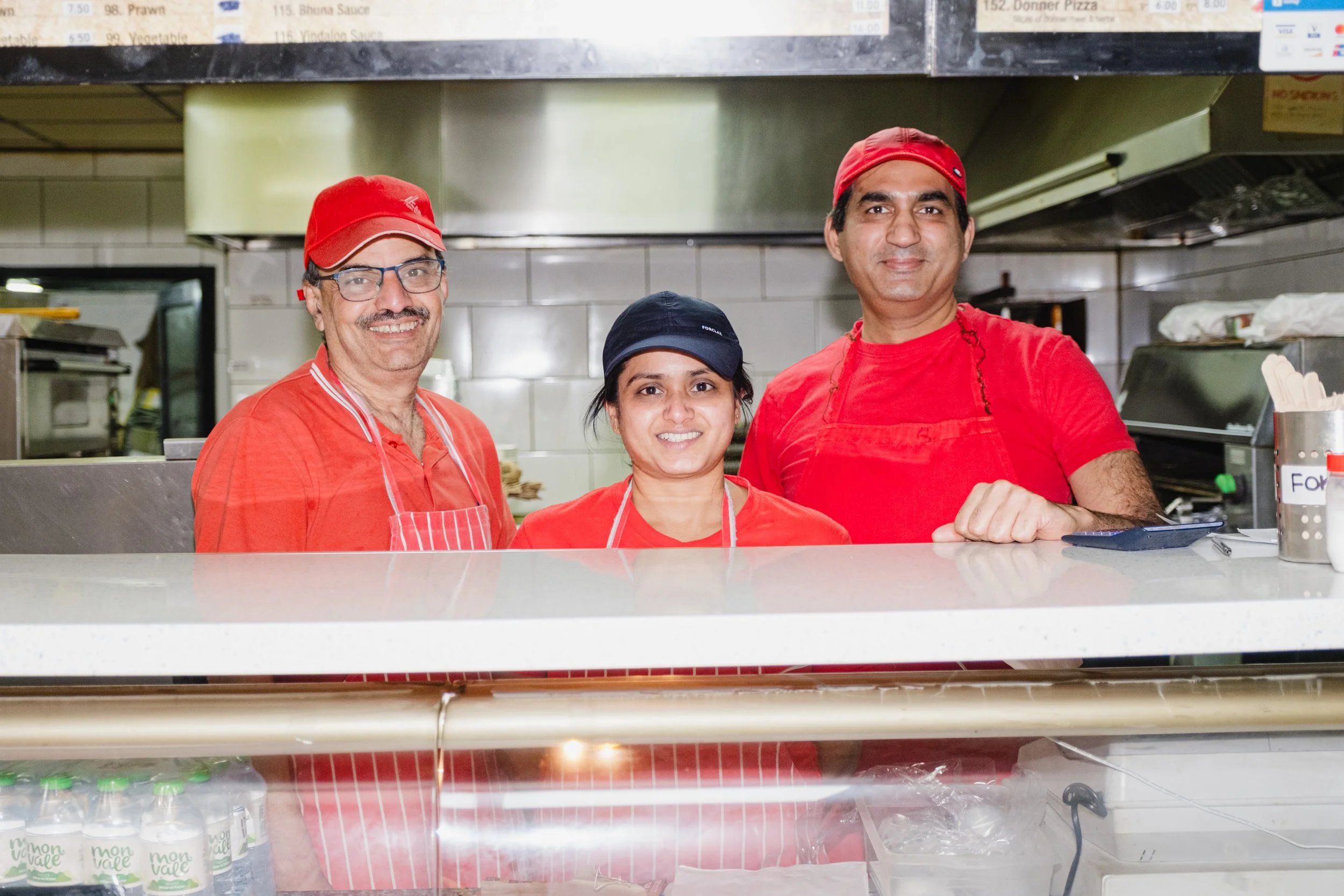 Staff members behind the counter at Marsden Spice and Pizza in Marsden, West Yorkshire.