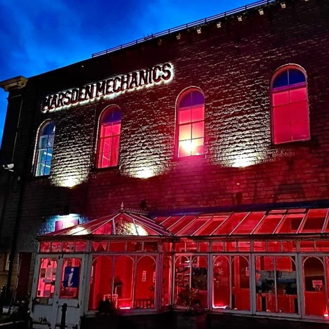 The outside of the Marsden Mechanics in Marsden, West Yorkshire, lit up at night.