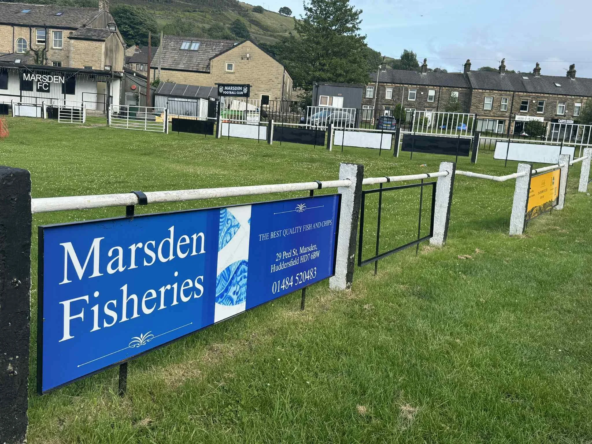 A Marsden Fisheries advert display at Marsden Football Club in Marsden, West Yorkshire.