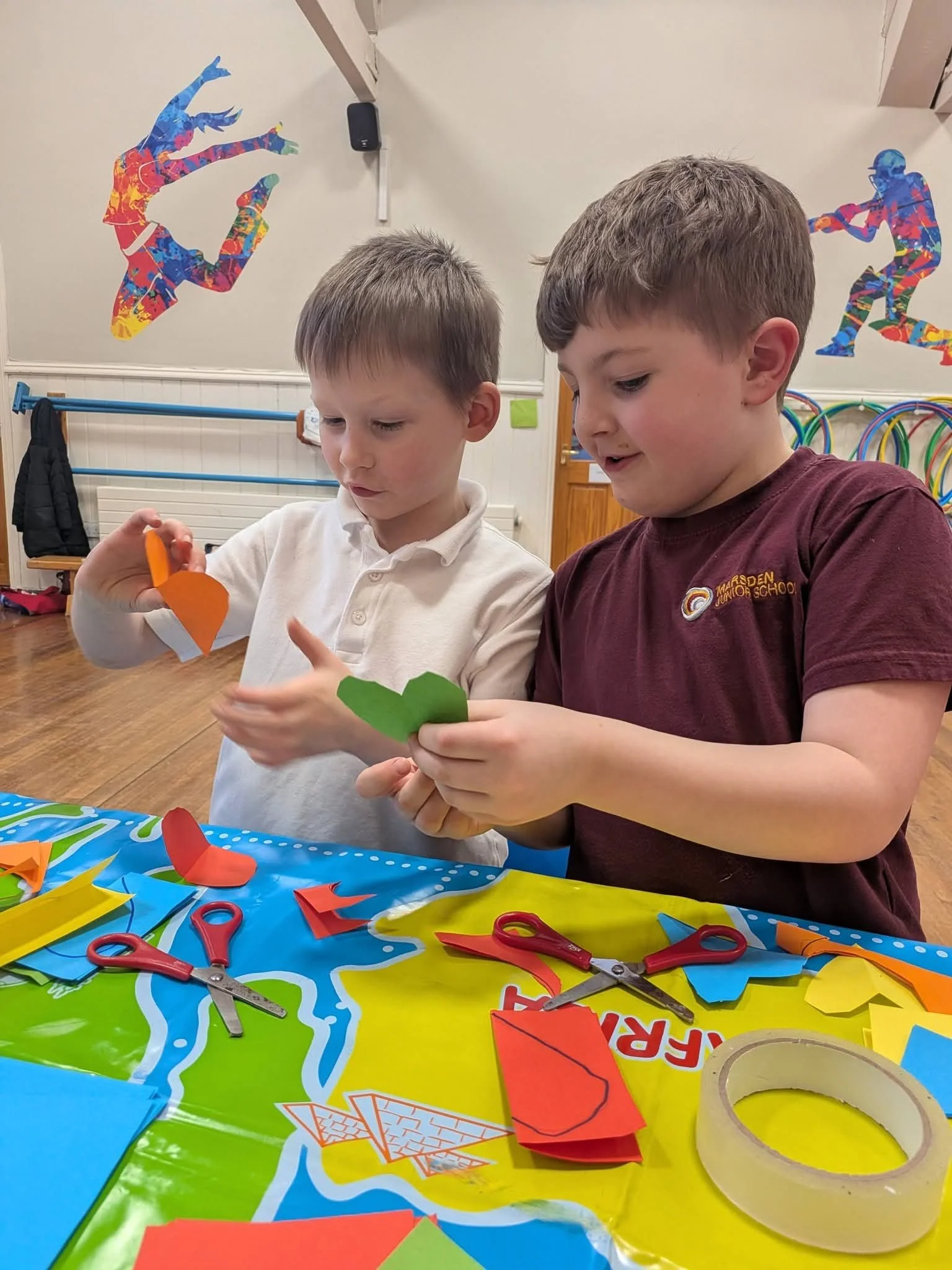 Children cutting paper shapes at Marsden Kids' Club in Marsden, West Yorkshire.