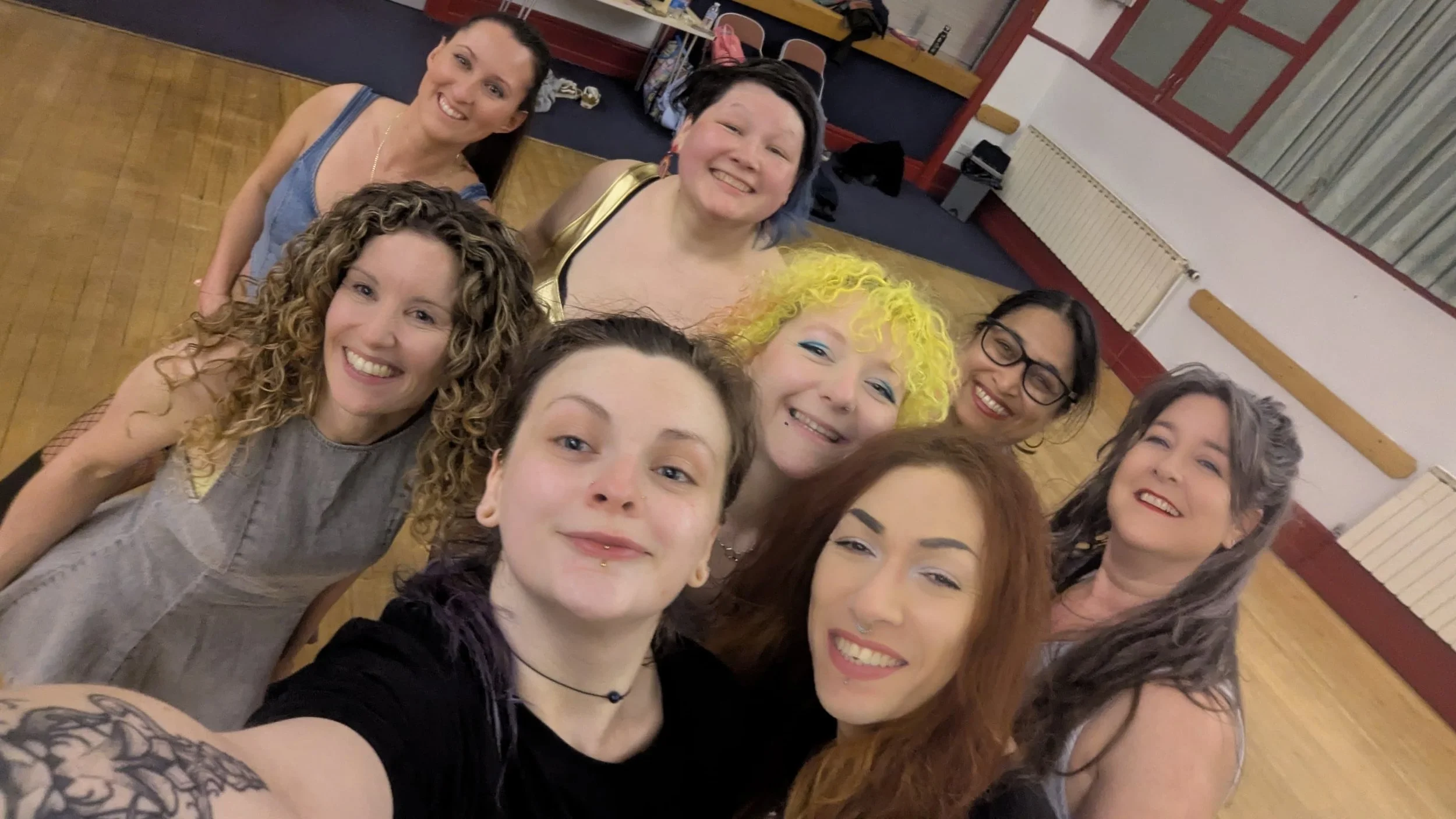 Members of a burlesque chair dance group smiling for the camera.