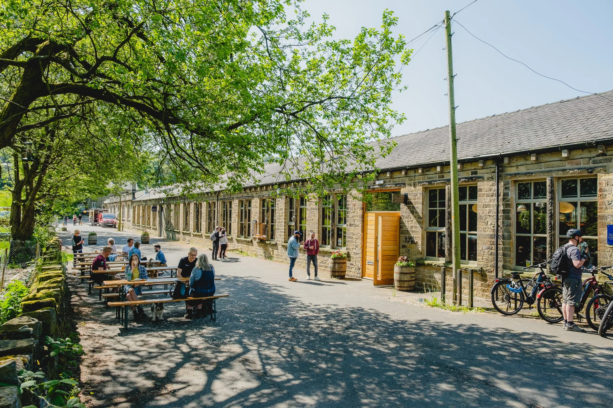 People enjoying the sunshine outside Dark Woods Coffee roastery.