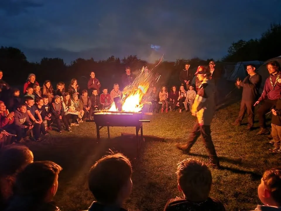 A group of 14th Huddersfield Marsden Scouts sitting around a campfire.