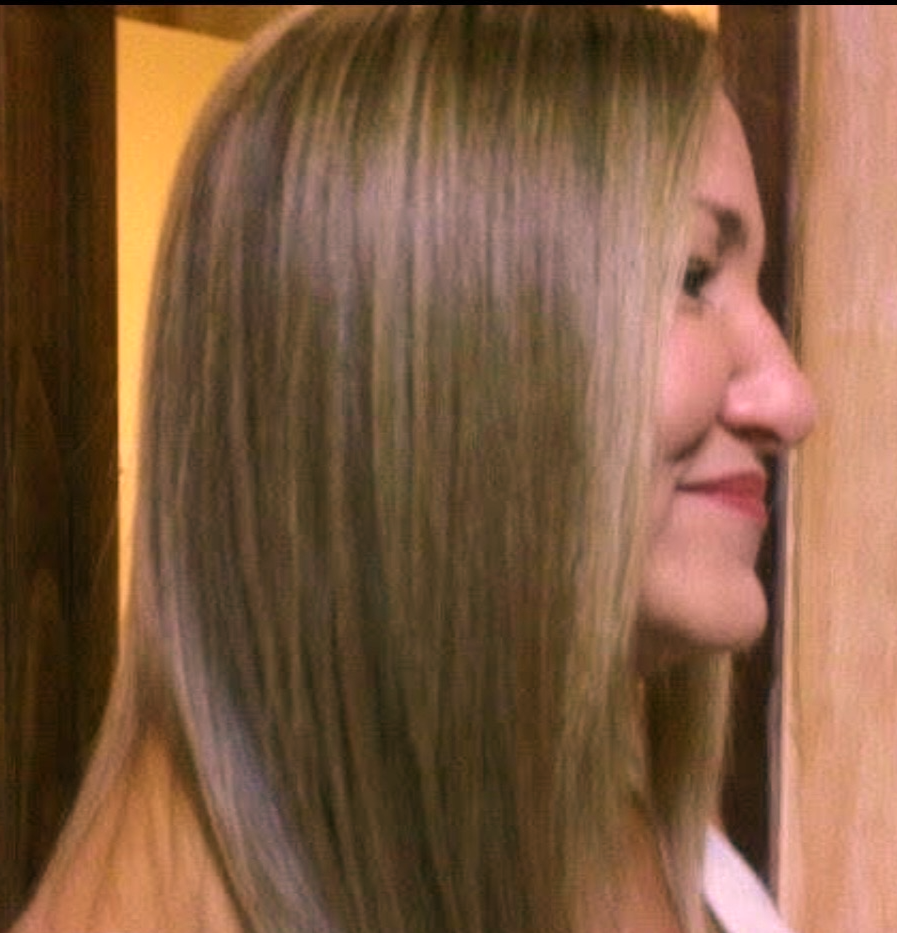 Profile of a woman with straight, shoulder-length blonde hair showing the results of a keratin. The hair is silky and shiny.