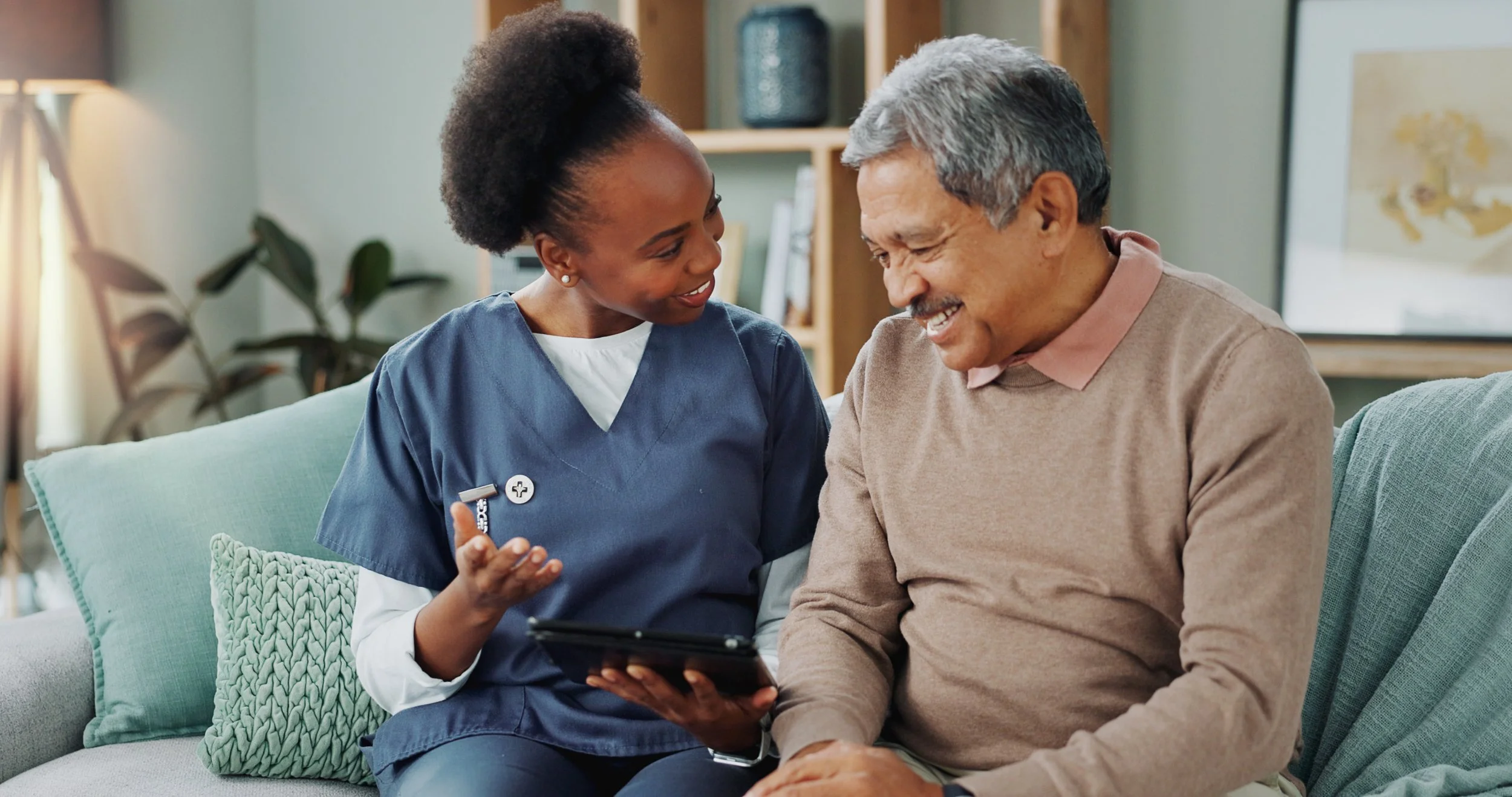 Carer visiting an older man at home and offering compassionate companionship and support.