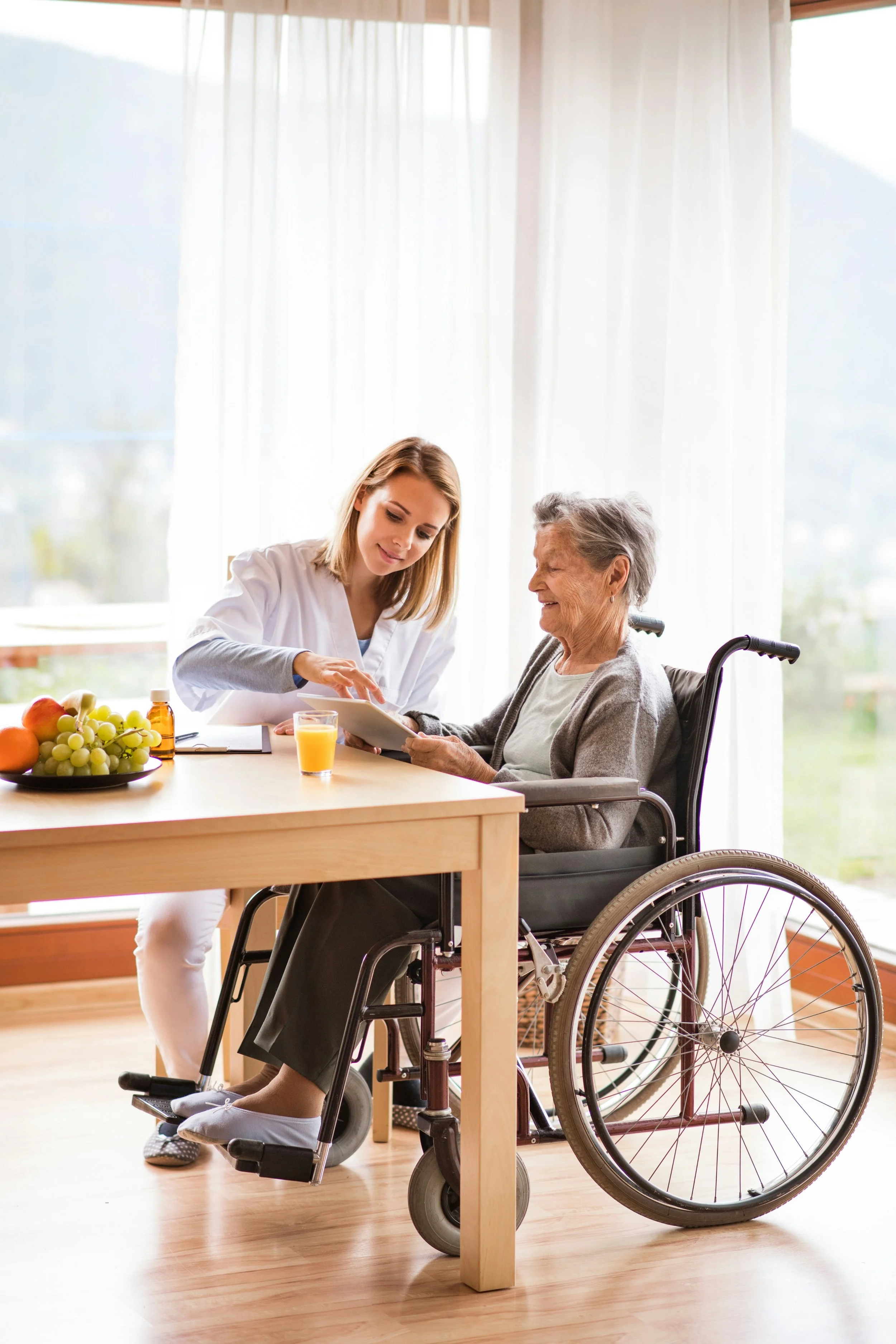 Carer helping an older woman stay connected and engaged during an in-home care visit.