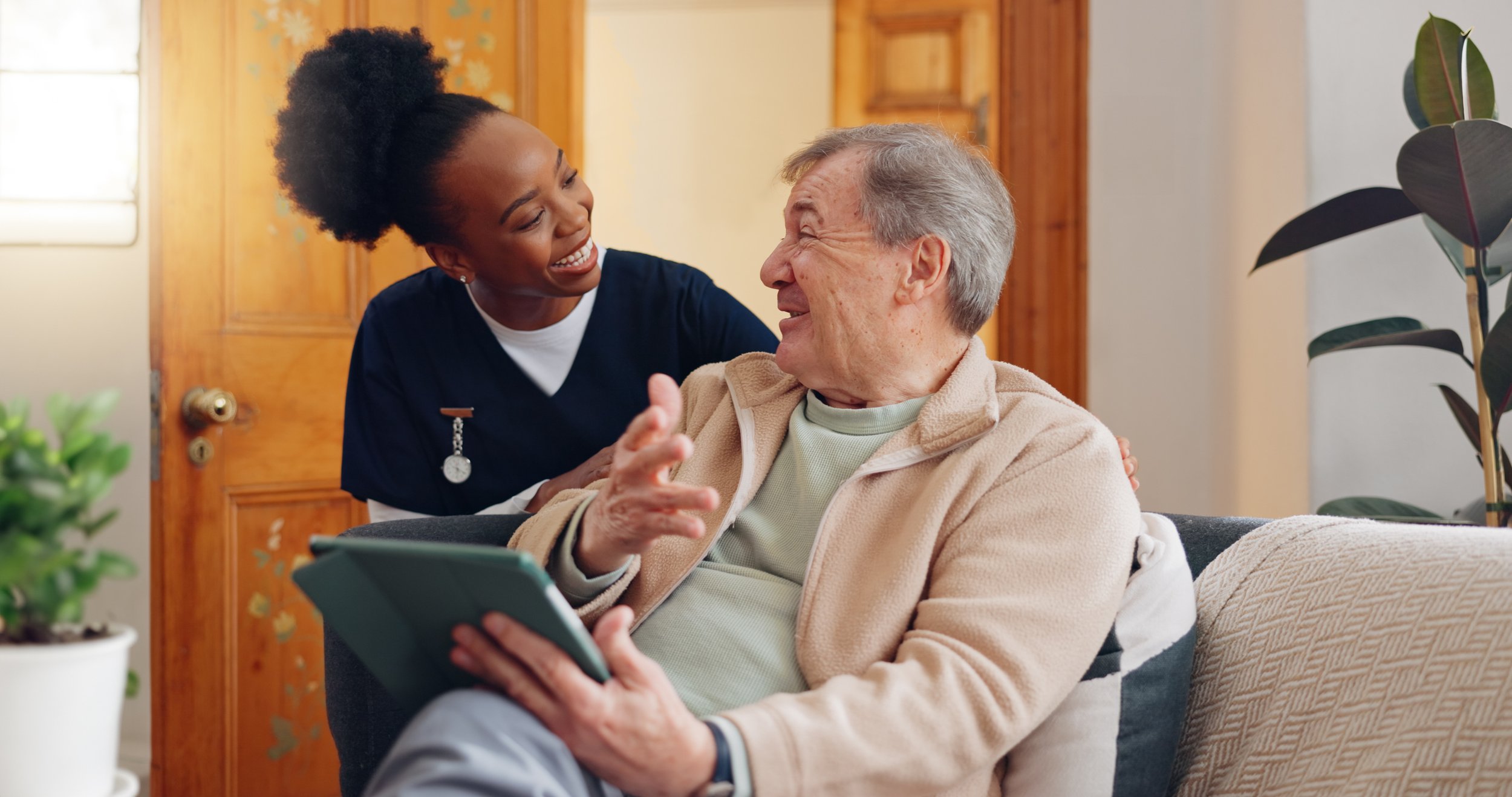 Friendly in-home carer providing companionship and support to an older client.