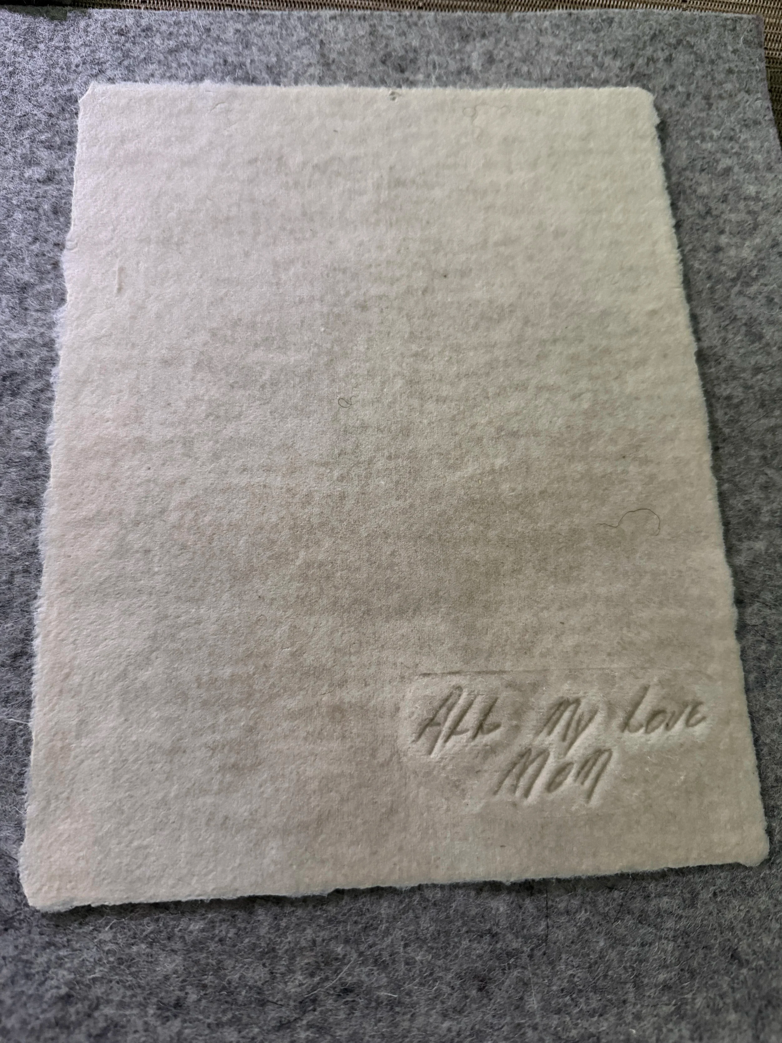 Handwritten message embossed into handmade memorial paper preserving a loved one's words.
