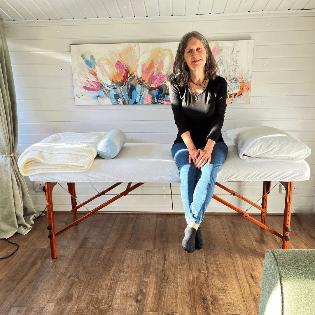 Katarina Tilley sitting inside the peaceful garden sanctuary on a Reiki couch at her meditation centre in Point Clear, Clacton-on-Sea, near Colchester.