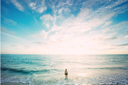 A vast expanse of sea and sky and a woman is observing it