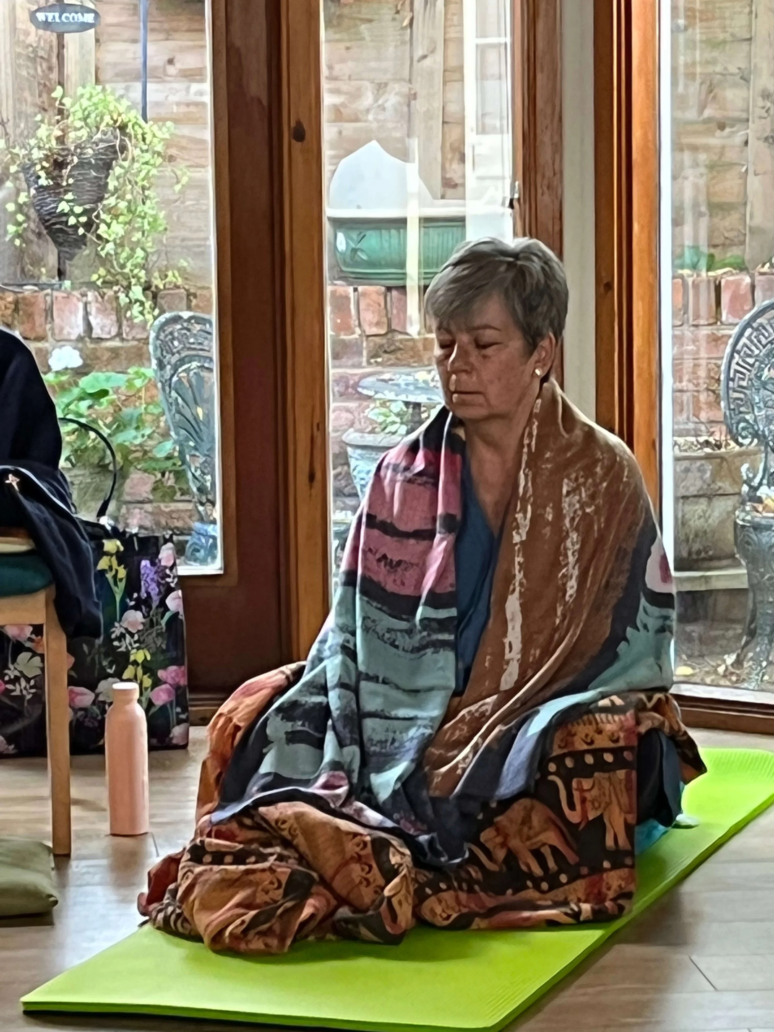 A student sitting comfortably in quiet meditation during a mindfulness meditation retreat serving Clacton and Colchester.