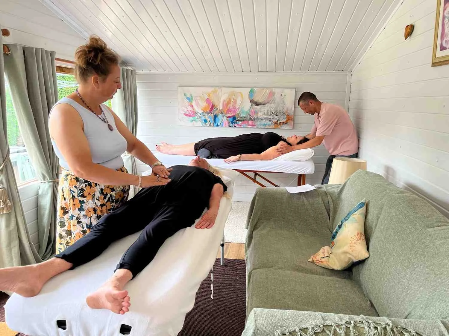 Four students participating in a practical training session, with two students practicing hands-on Reiki healing treatments on two other participants during a course at the Katarina Tilley Meditation Centre, in Point Clear, near Clacton and Frinton.