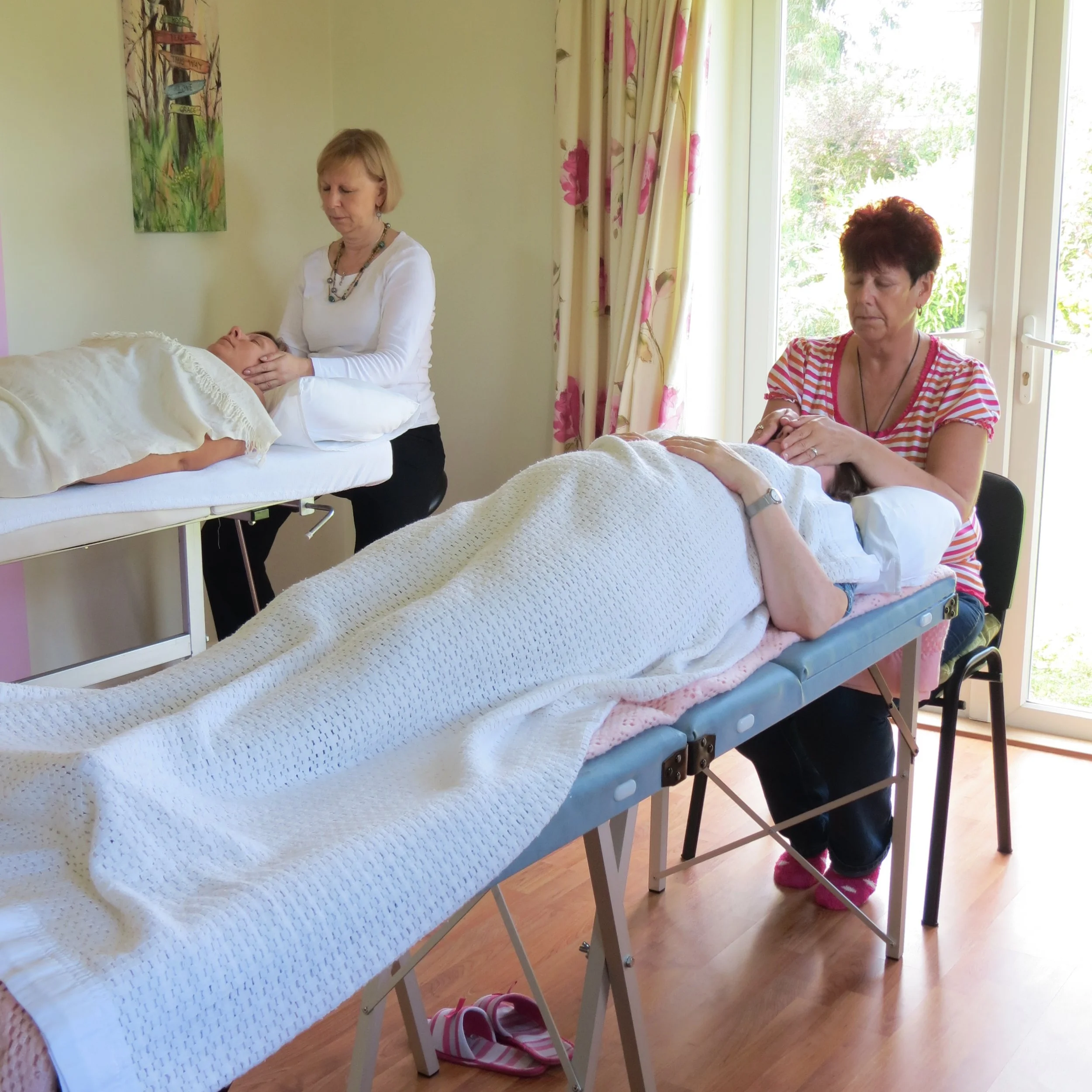 Two students practicing advanced energy healing techniques during a Reiki 2 certification course taught by Katarina Tilley, serving clients across Colchester and Clacton-on-Sea, Essex.