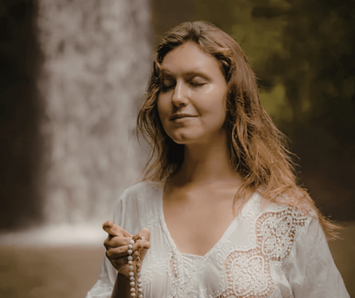 A woman using mala beads to find inner peace, representing the devotional path taught in the Spiritual Growth Course, The Way to Inner Peace, at the Katarina Tilley Meditation Centre.