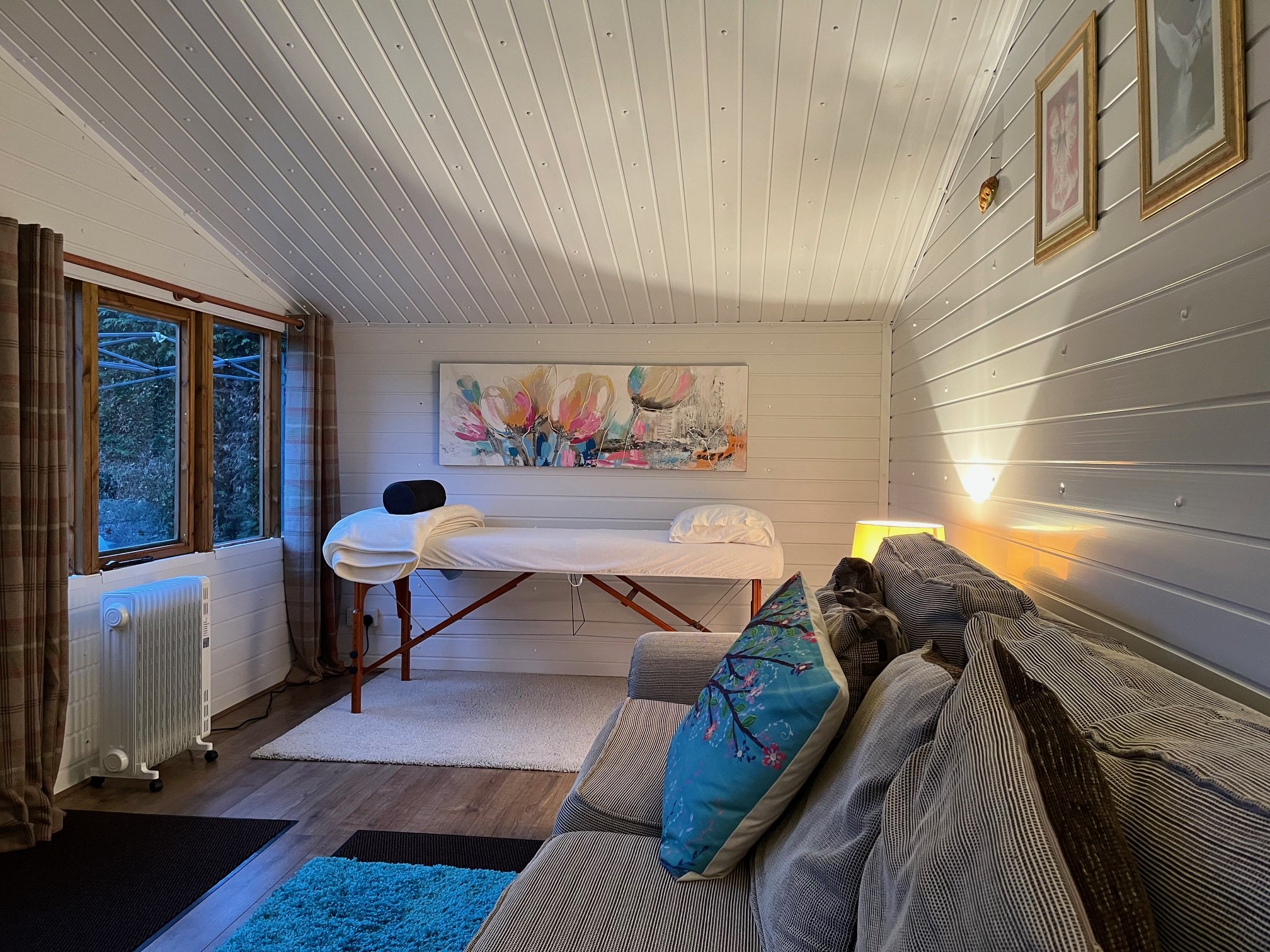 A softly lit evening view inside the cozy, warm Reiki healing room at the Katarina Tilley meditation sanctuary in Point Clear, welcoming clients from Harwich.