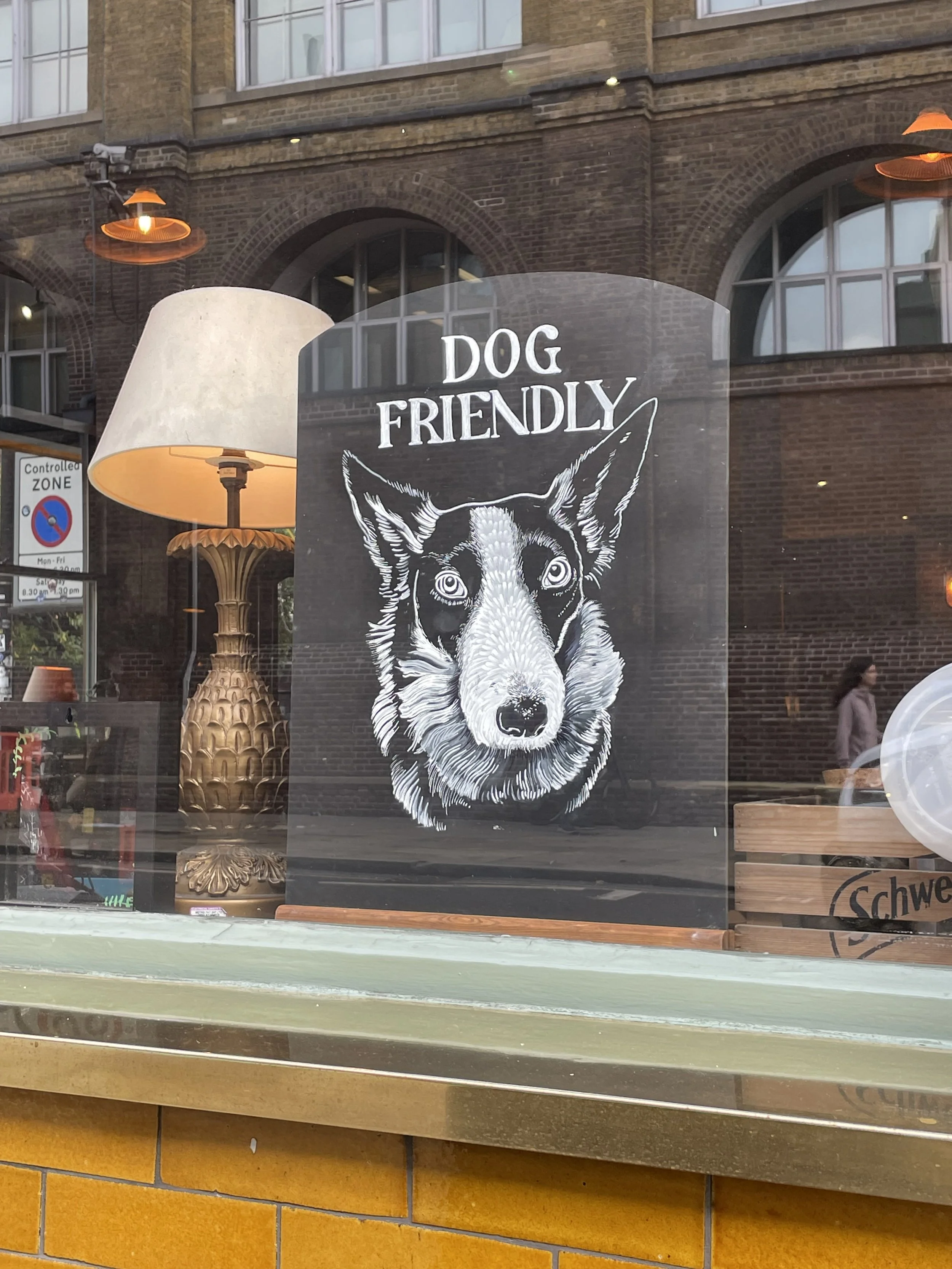 A sign that says 'Dog Friendly' with an illustration of a dog's face.