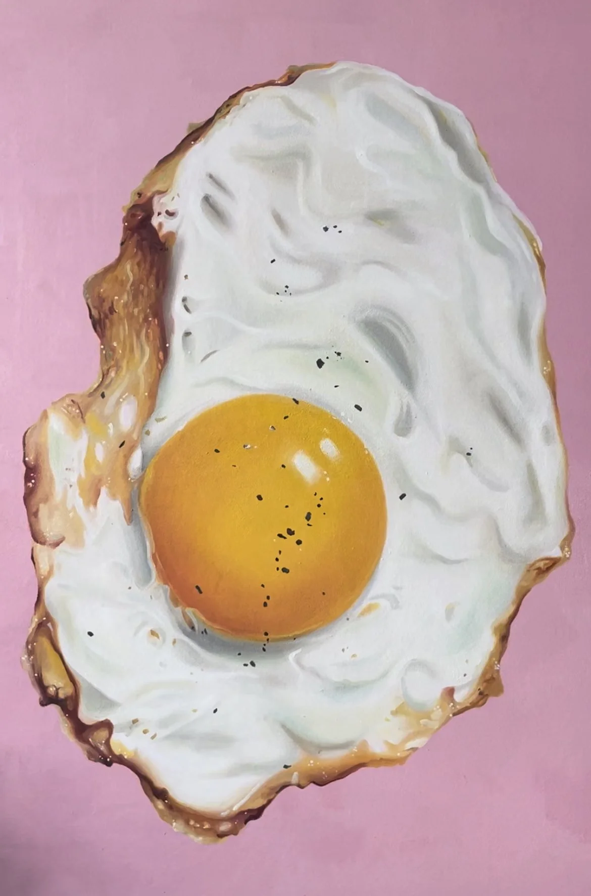 A fried egg with a bright yellow yolk on a pink background.