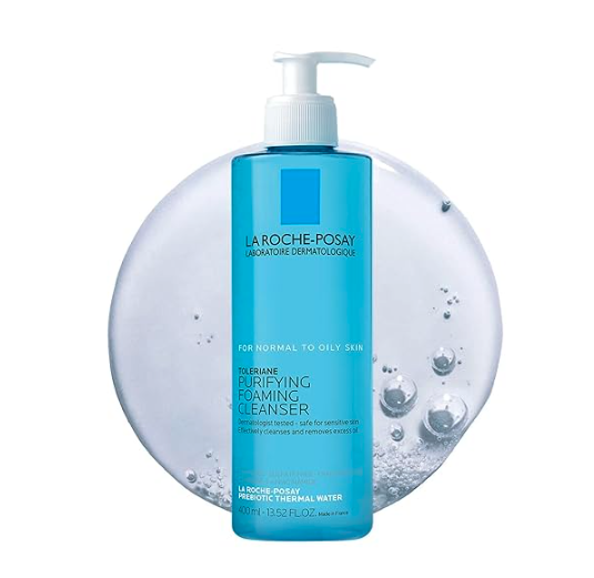 A blue bottle of La Roche-Posay Purifying Foaming Cleanser for normal to oily skin, with a pump dispenser, placed in front of textured water and bubbles background.