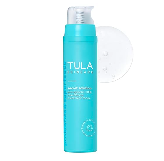 Blue bottle of TULA Skincare Secret Solution Pro-Glycolic 10% Resurfacing Treatment Toner with a white pump dispenser and a small amount of clear liquid next to it.