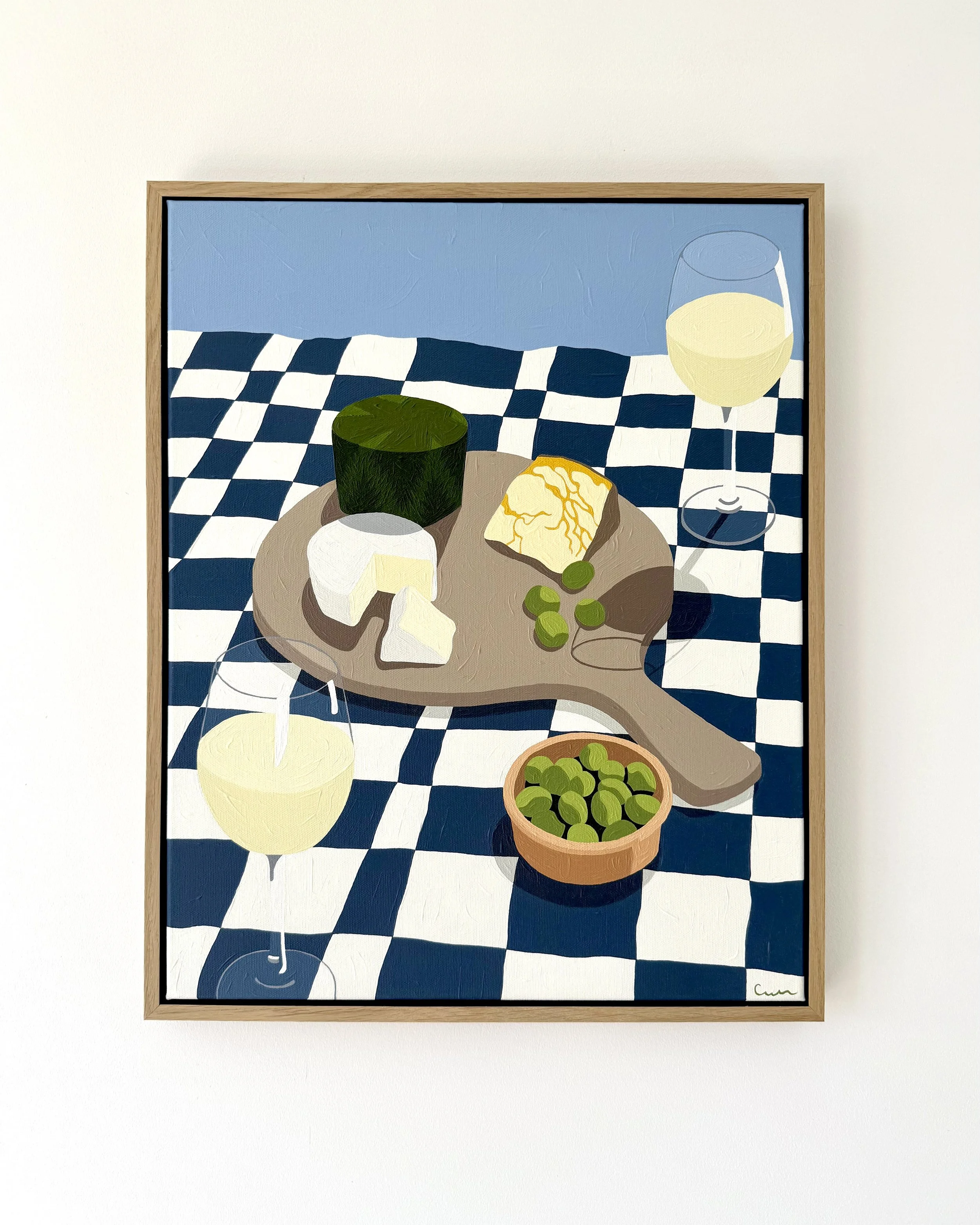 Painting of a table with a cheese board, a bowl of olives, and white wine on a checkered tablecloth.