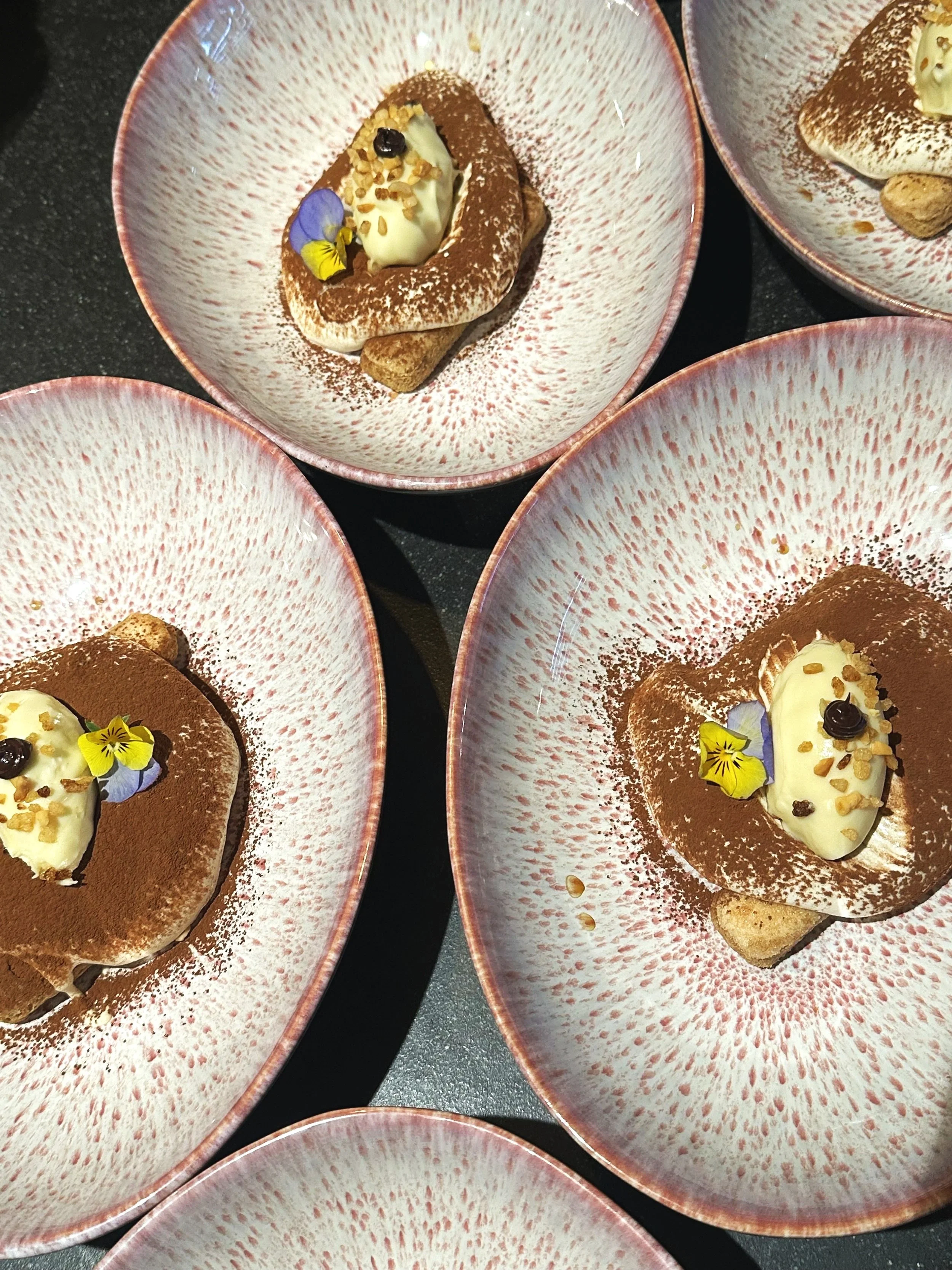 CHEF'S TIRAMISU   Lange vingers gedoopt in een koffie & marsala, afgemaakt mascarponecrème en natuurlijk cacao. Chef's twist? Een extra bonbon van witte chocolade gevuld met romige koffie mousse