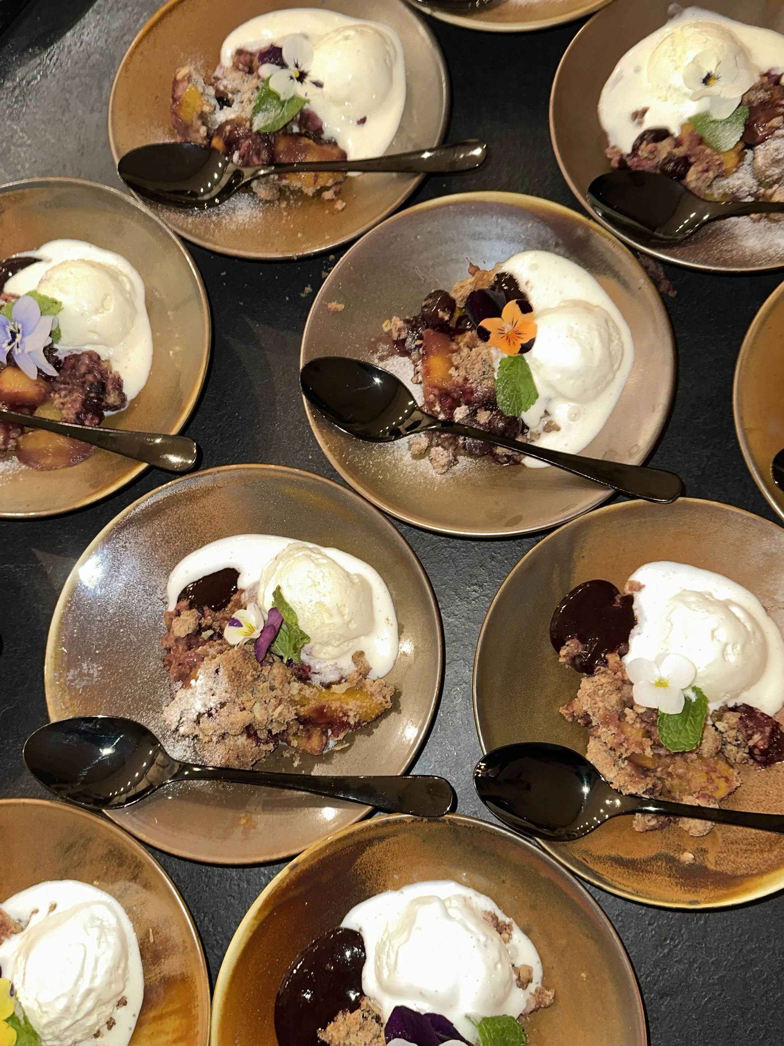 PERZIK CRUMBLE   Warme crumble met perzik en blauwe bes, geserveerd met vanille ijs & bosvruchtensaus