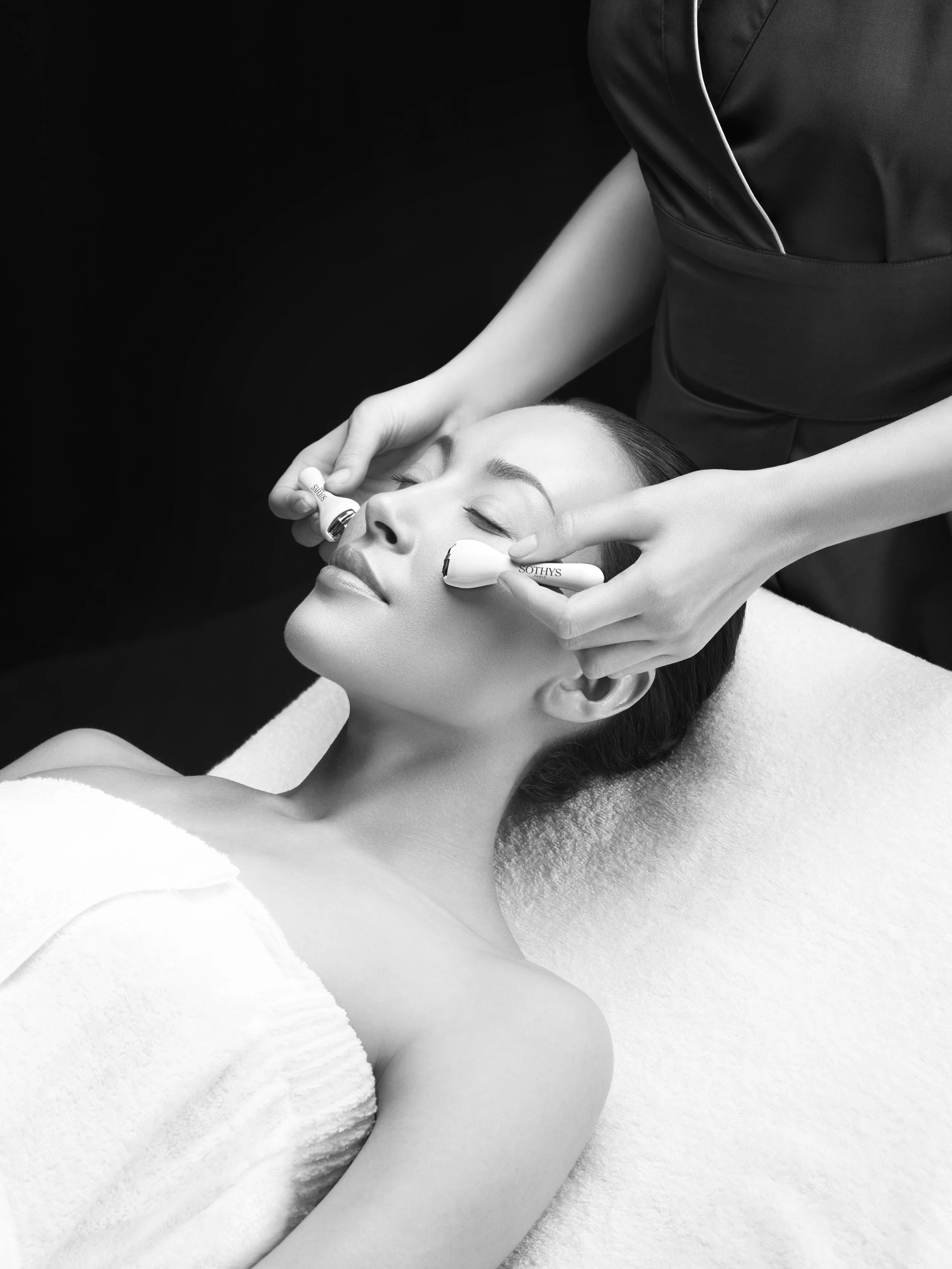 Frau erhält eine Gesichtsmassage mit einem elektrischen Gerät in einem Spa.
