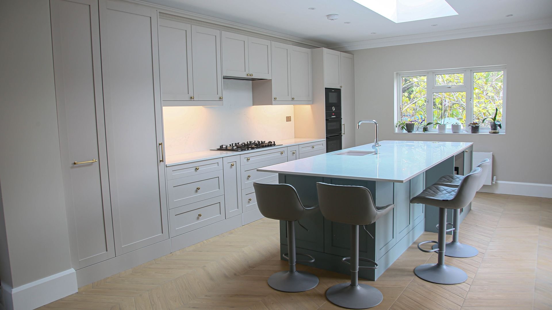 Bright shaker-style kitchen with island seating, renovated by RELM Interiors