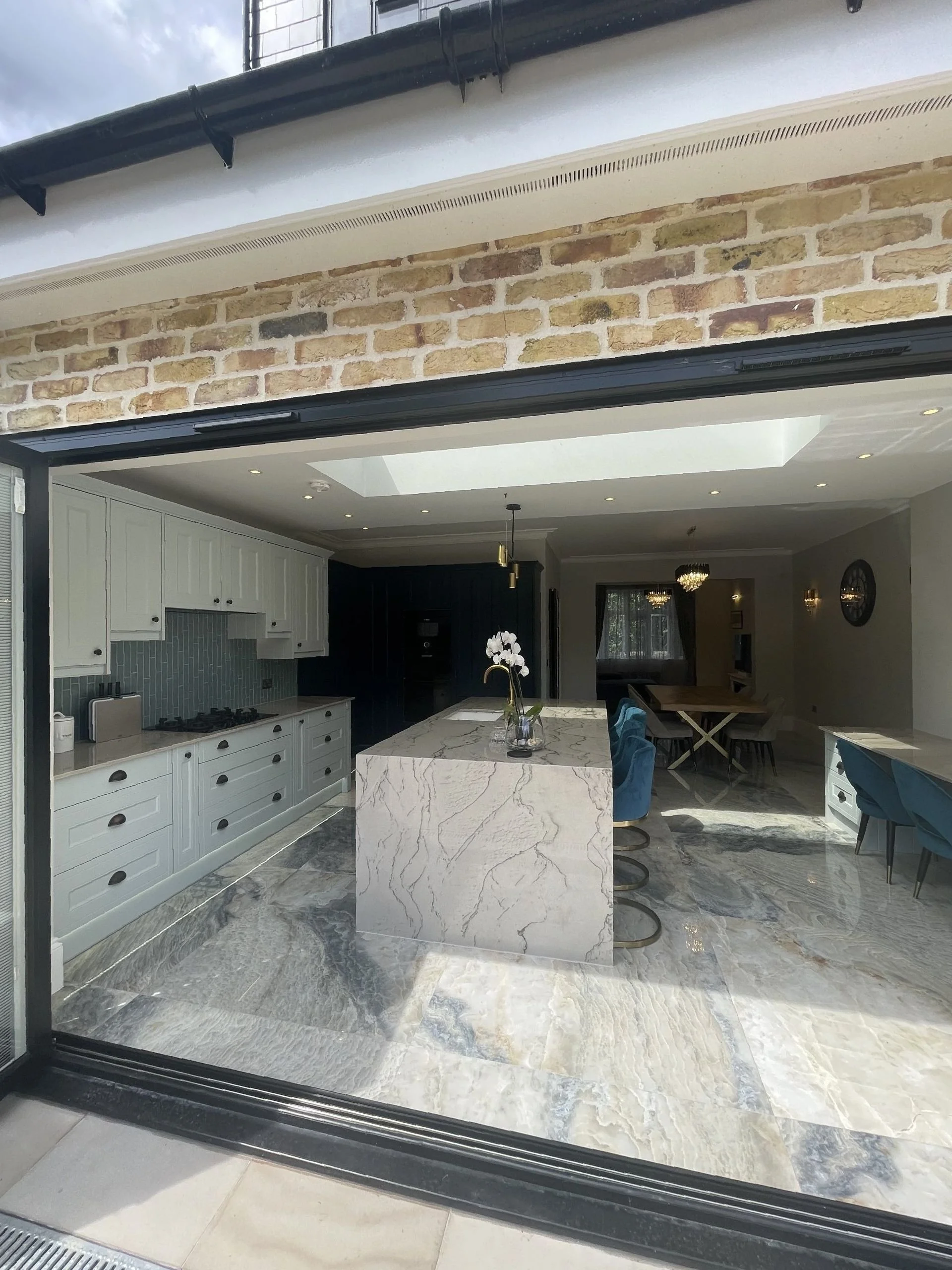Kitchen in a RELM rear extension with a marble island and roof light